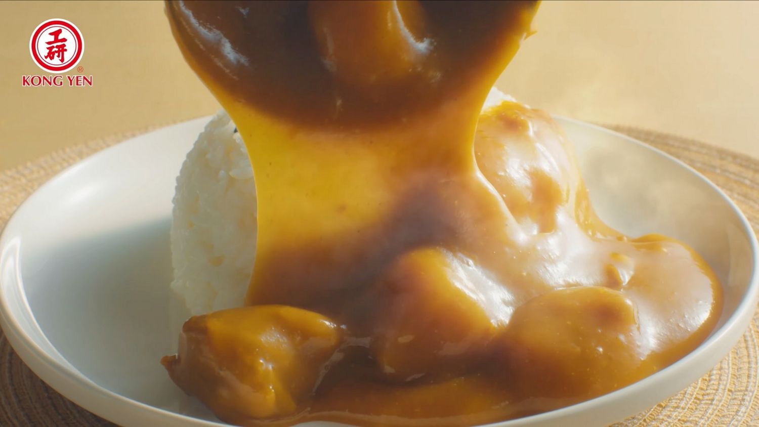 Thick caramel sauce being poured over a dessert plate in a close-up shot.