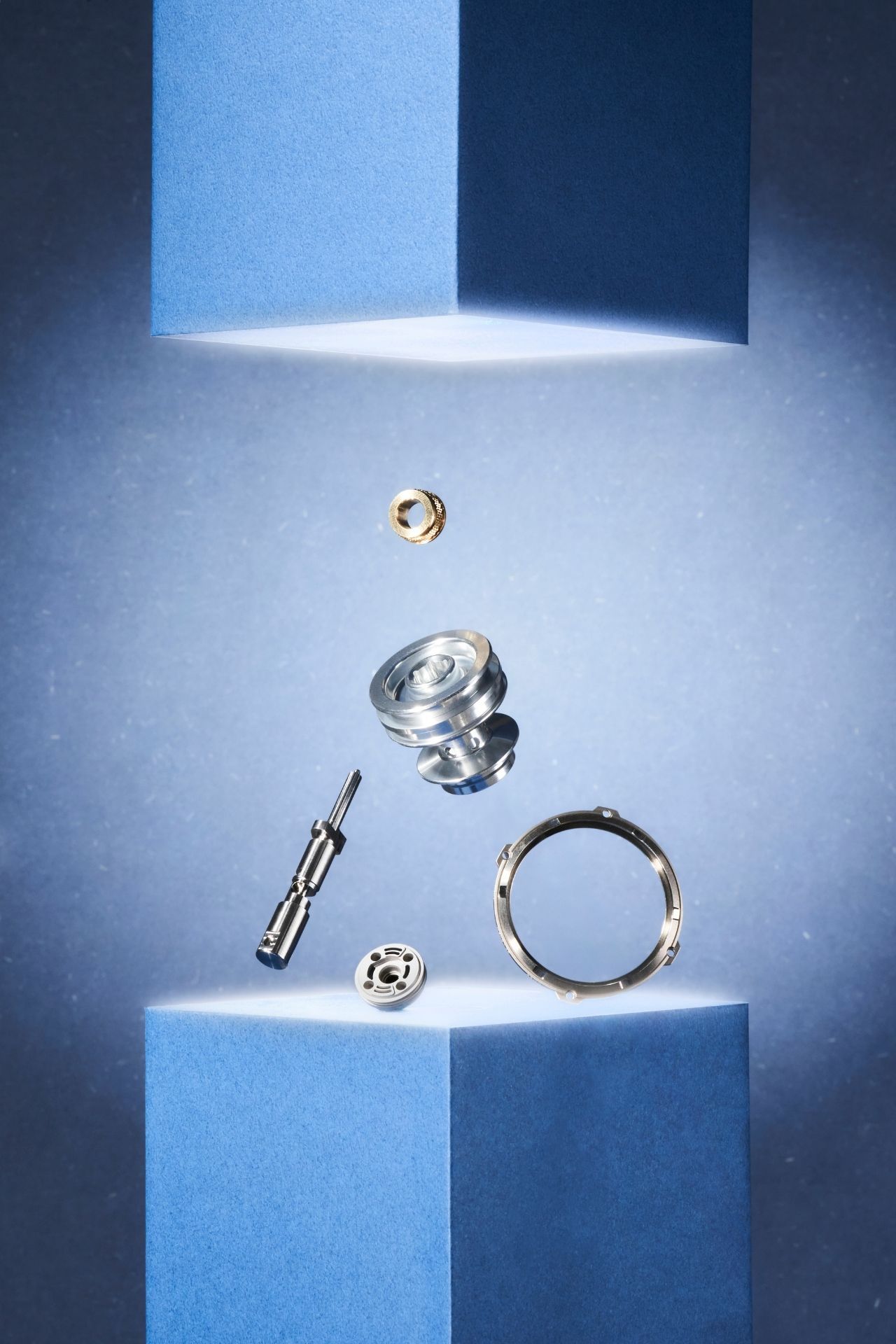 Sequence of jewelry pieces floating and separating against a blue and white gradient background.