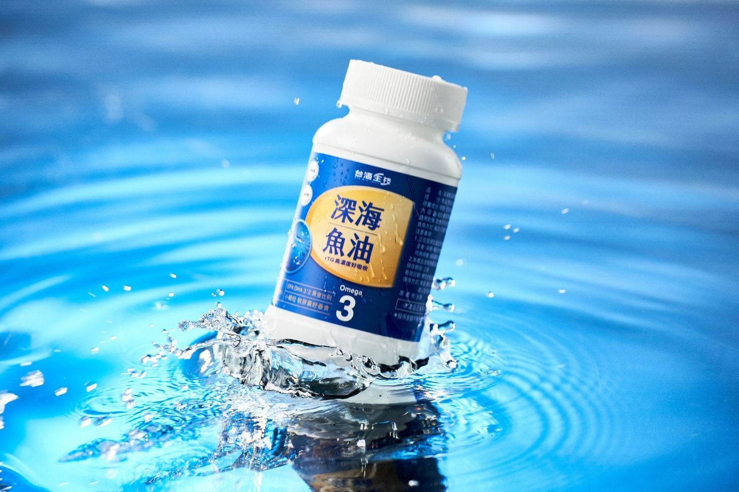Deep sea fish oil supplement bottle splashing in clear blue water, omega-3 dietary supplement with Chinese label.