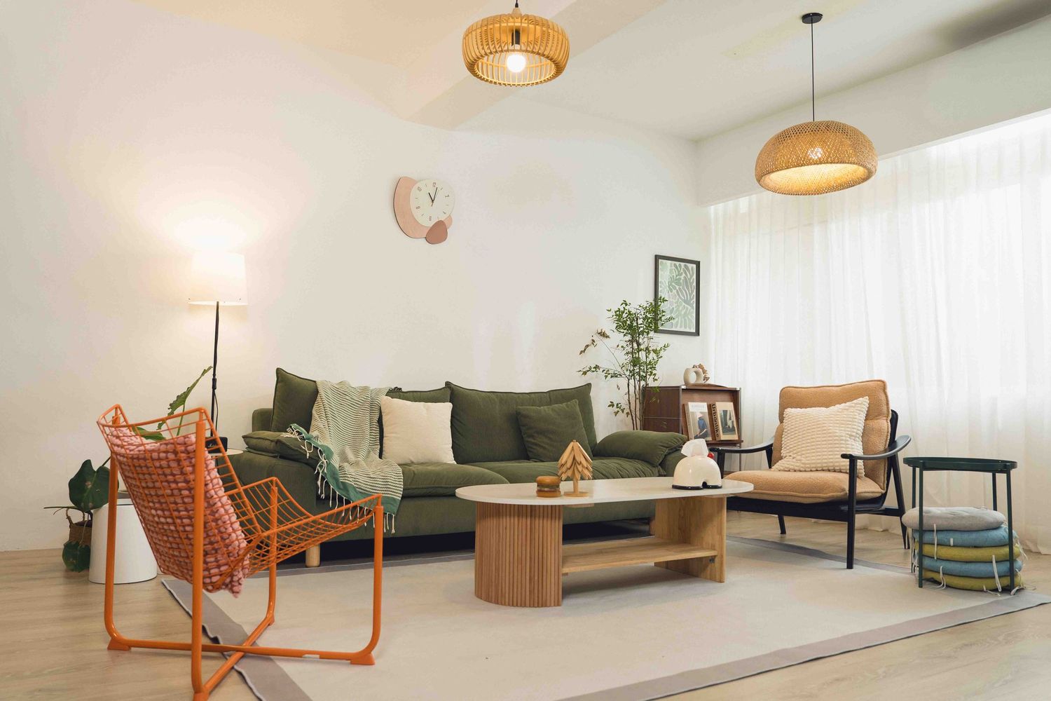 Modern living room with rattan pendant lights, white walls, and minimalist furniture featuring warm wood accents throughout.