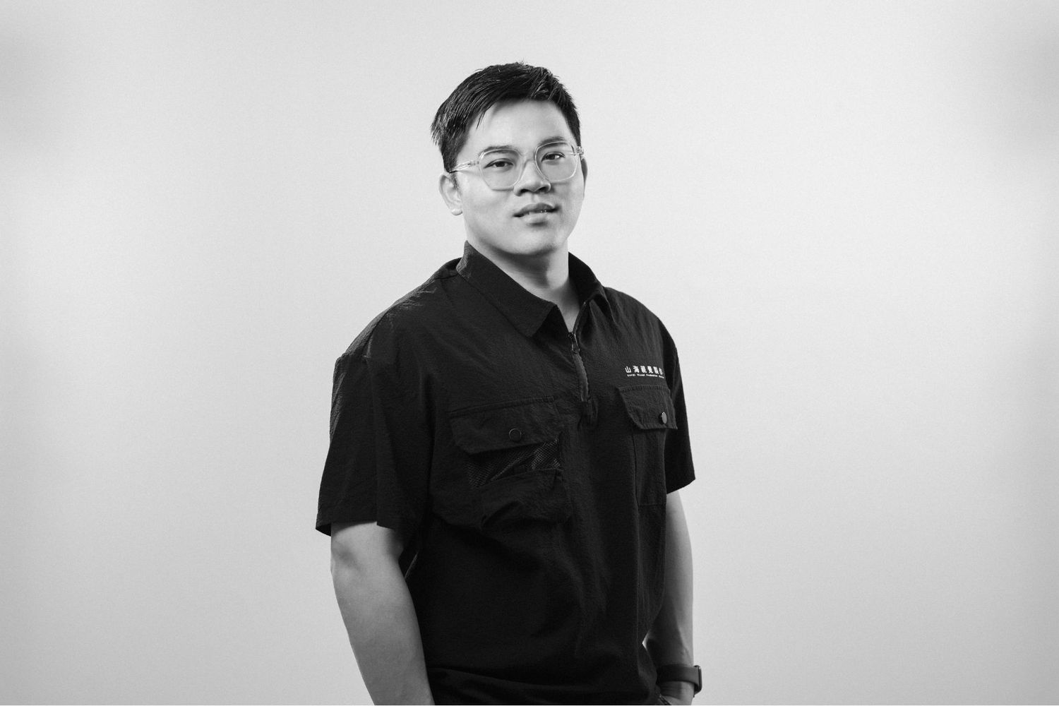 Professional wearing black polo shirt stands against light background in series of profile and front-facing poses.