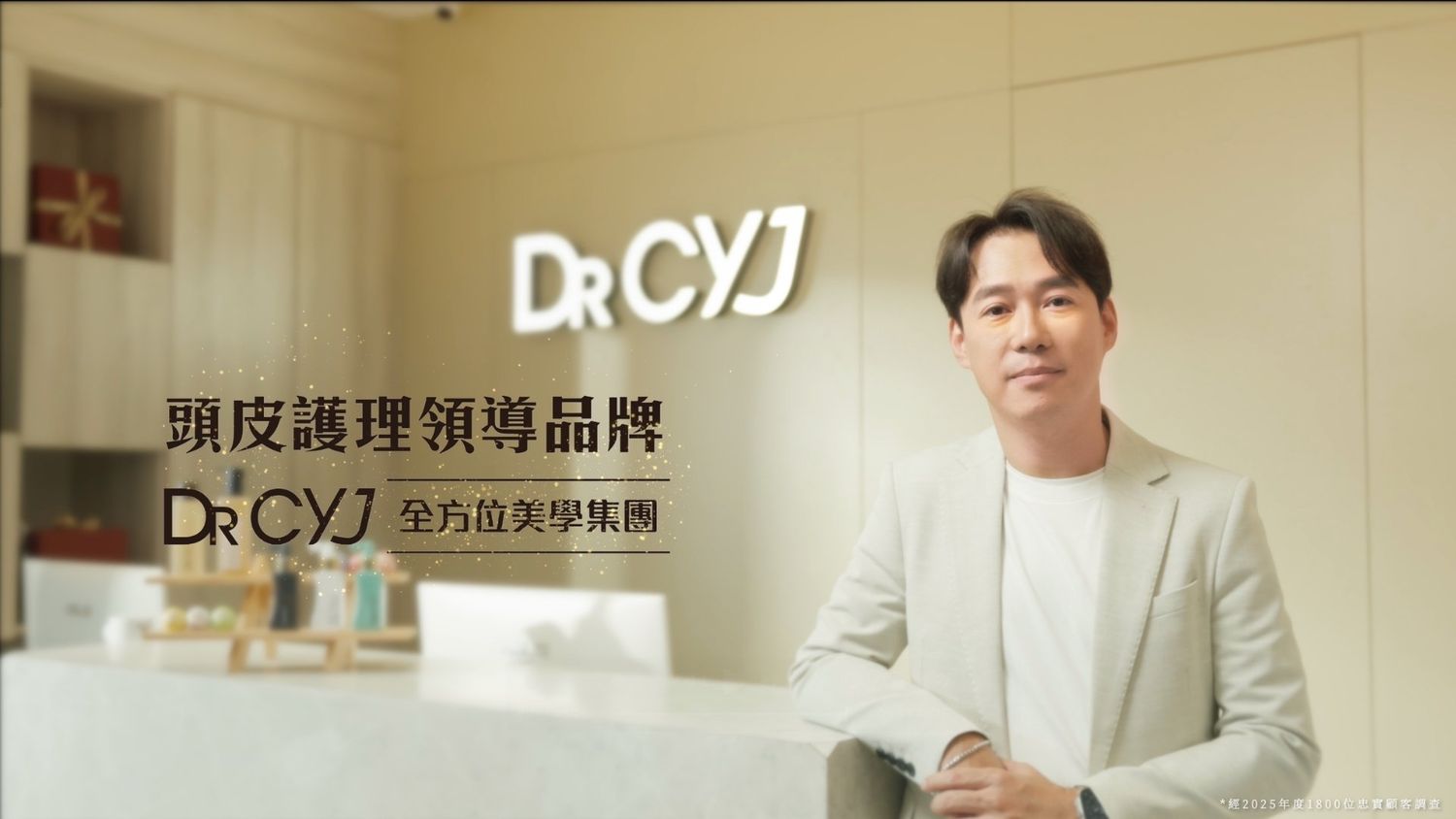 Man in white blazer poses beside Dr. CYJ hair scalp care brand logo with Chinese text in a modern interior setting.