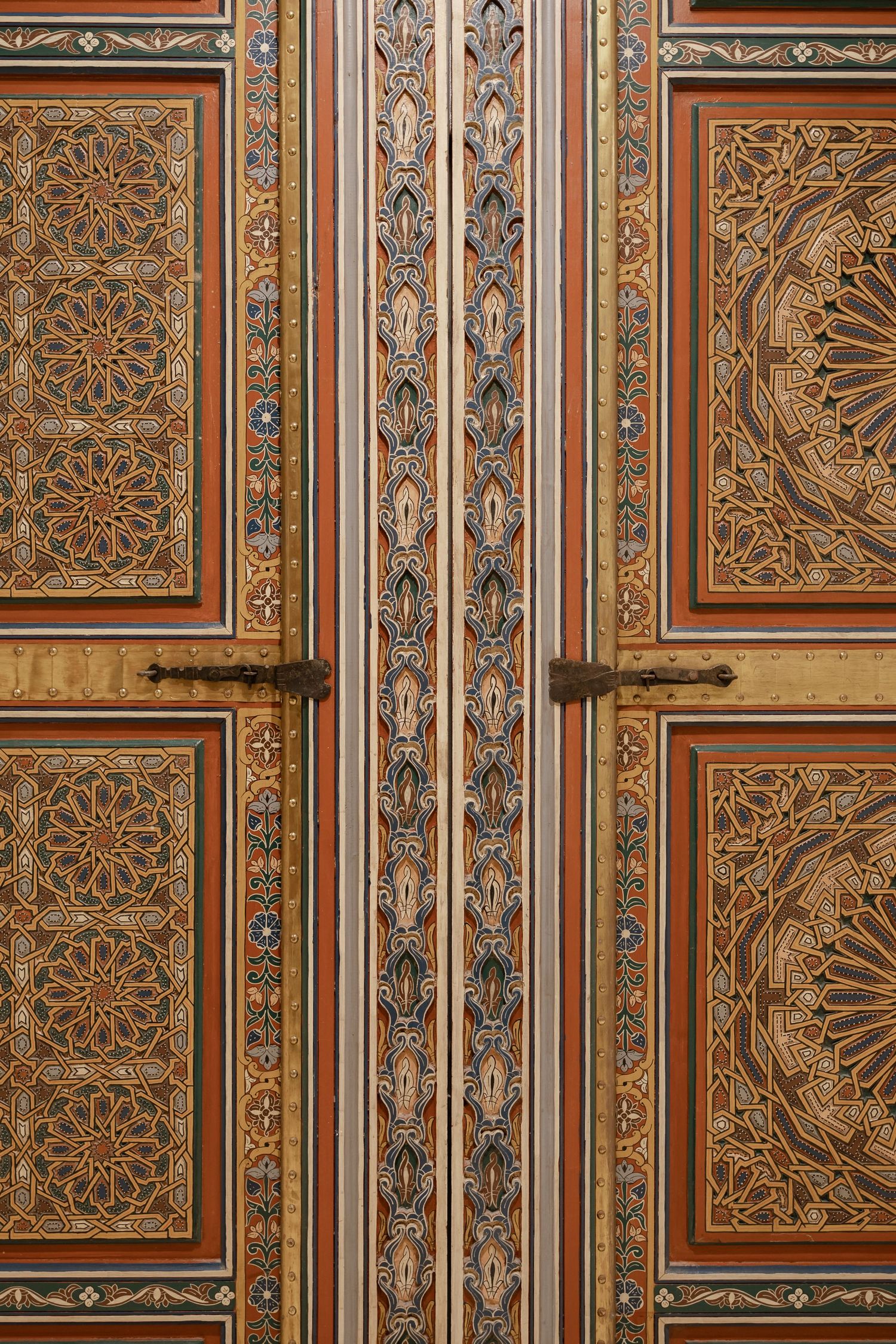 Ornate Moroccan wooden door with intricate geometric patterns and colorful painted details.