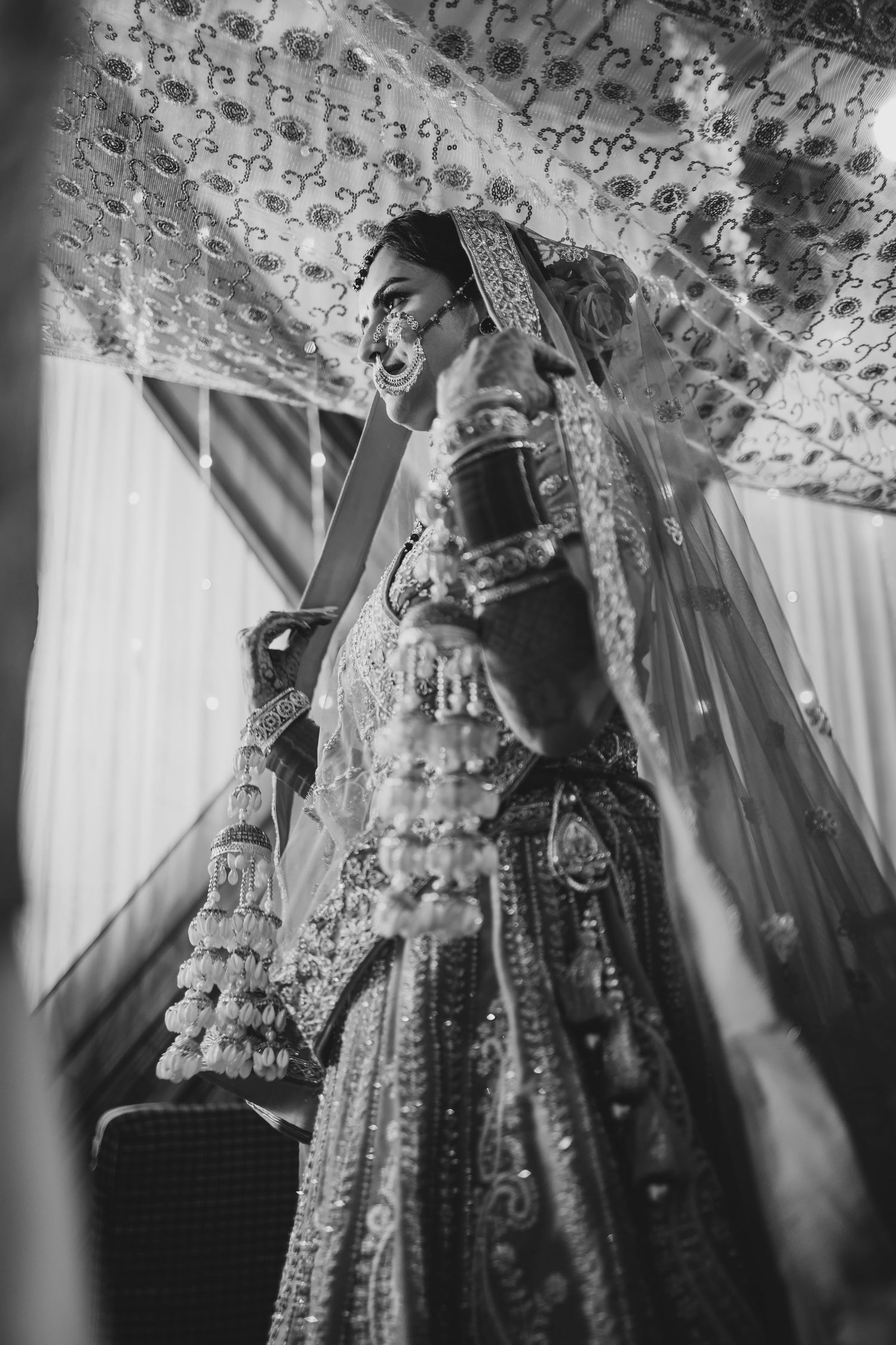 Black and white photo of an Indian bride in traditional bridal attire with jewelry and veil.