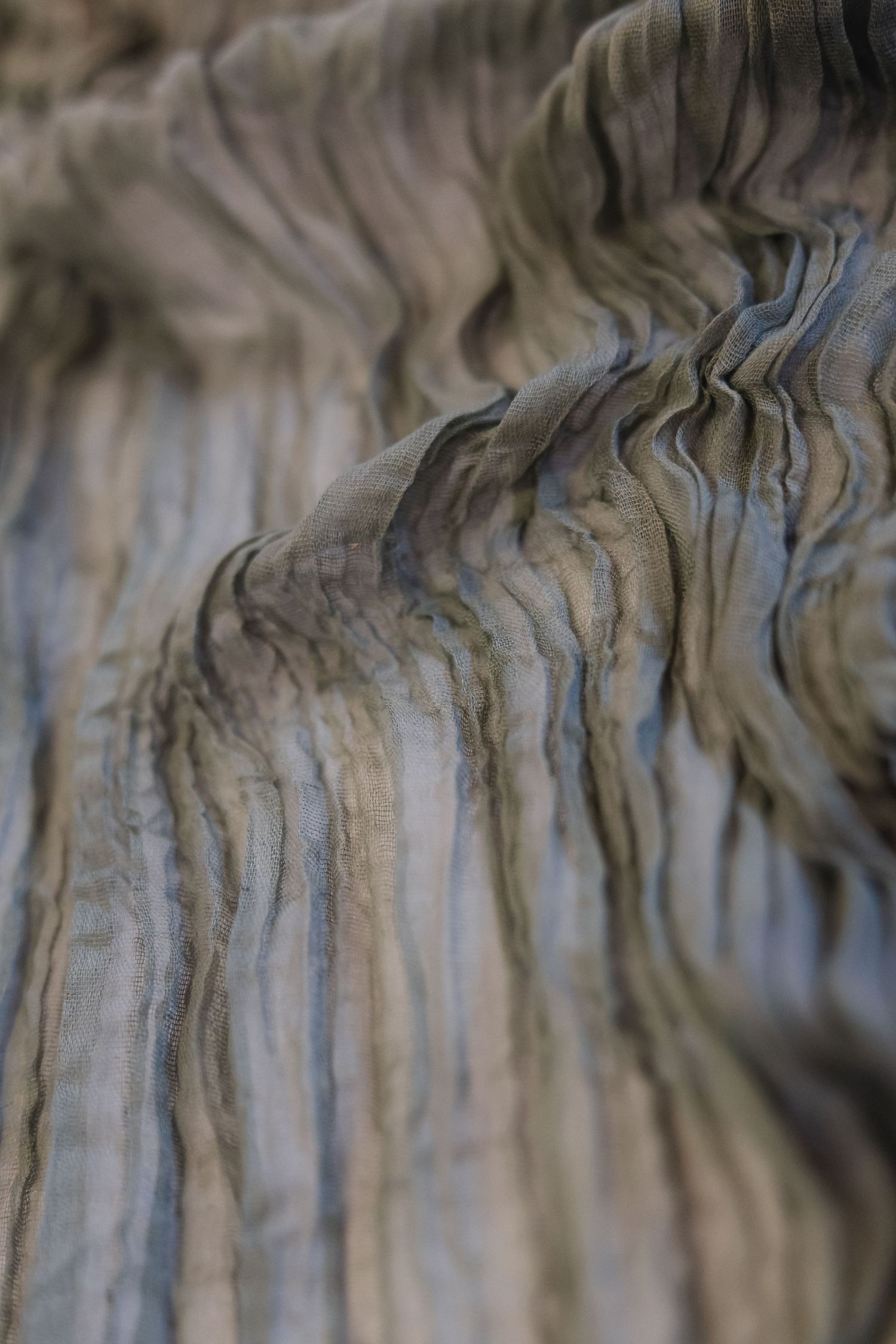 Close-up of layered sedimentary rock formations showing natural wavy striations in gray and brown tones.