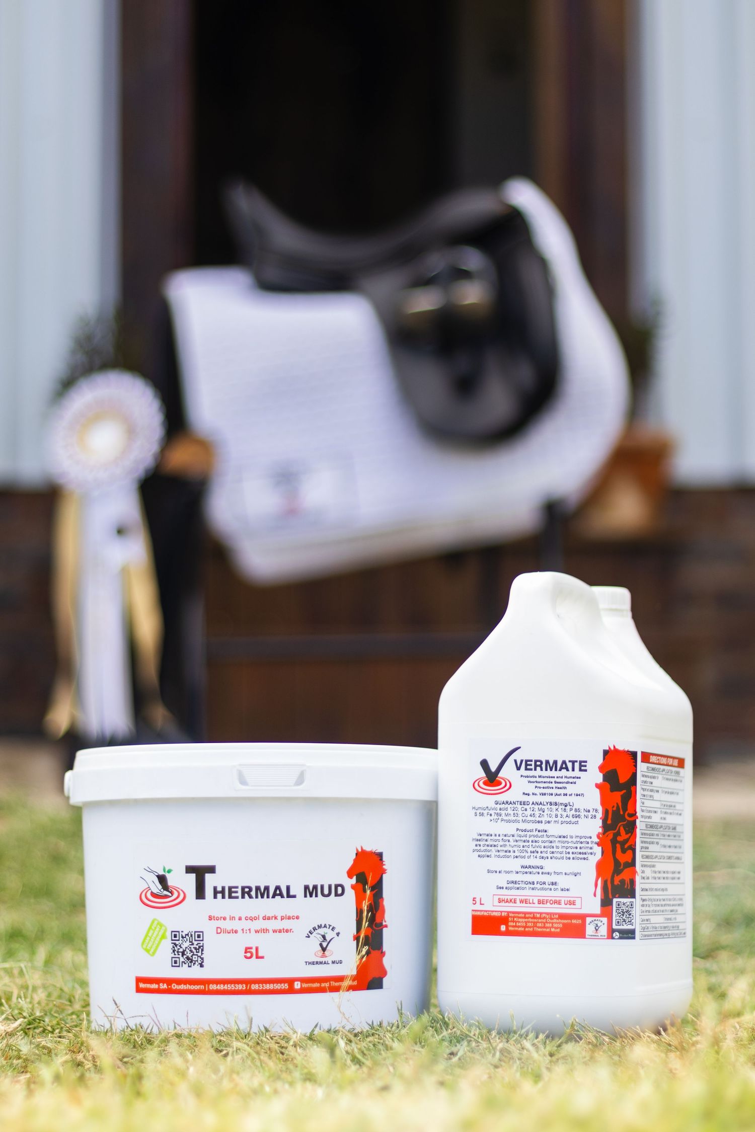Veterinary care products displayed on grass with white containers and red labels.