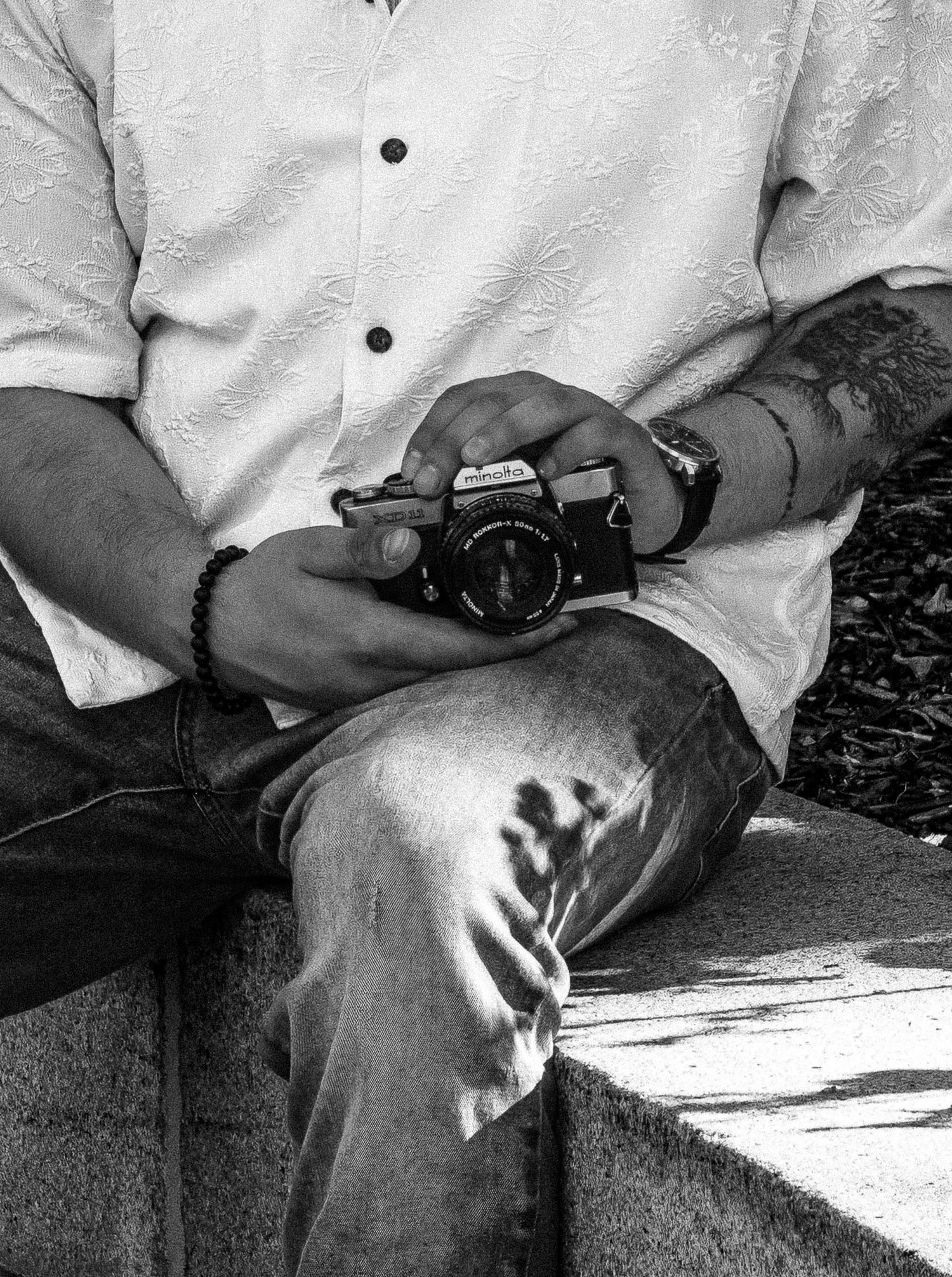 A series of black and white close-up photos showing hands holding and manipulating a small device or object.