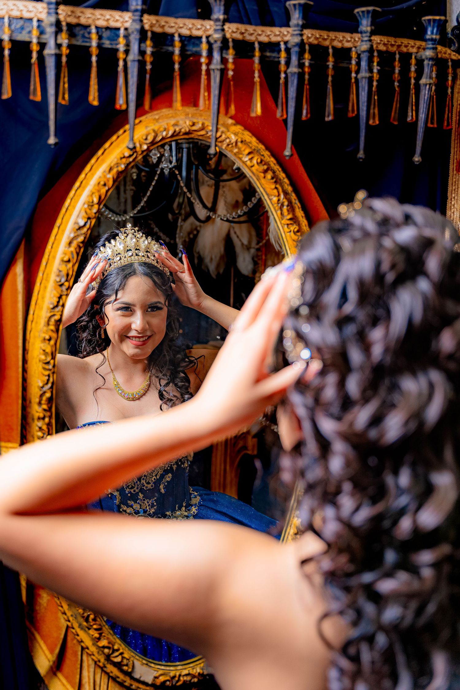 Mirror reflection shot showing an ornate gold frame and elegant blue gown with decorative details.