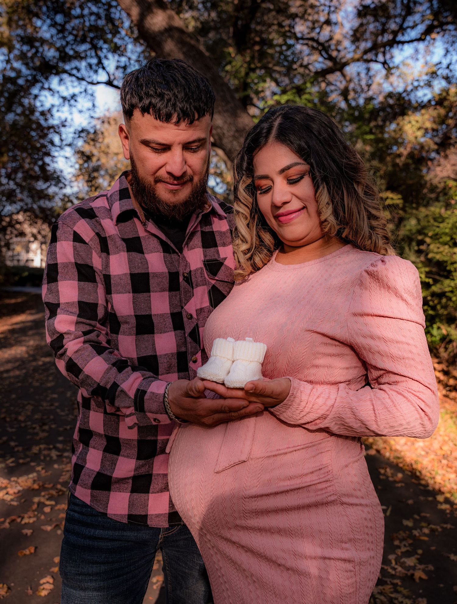 Family sharing special moment with ultrasound photos during fall photoshoot.