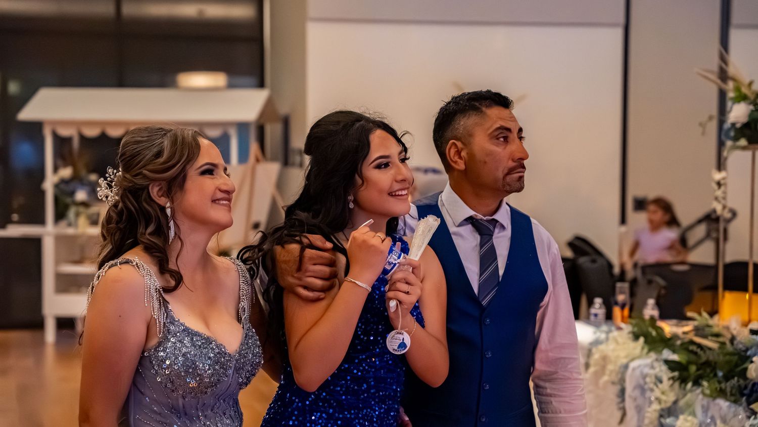 Panoramic view of a formal dance event with people in elegant attire.
