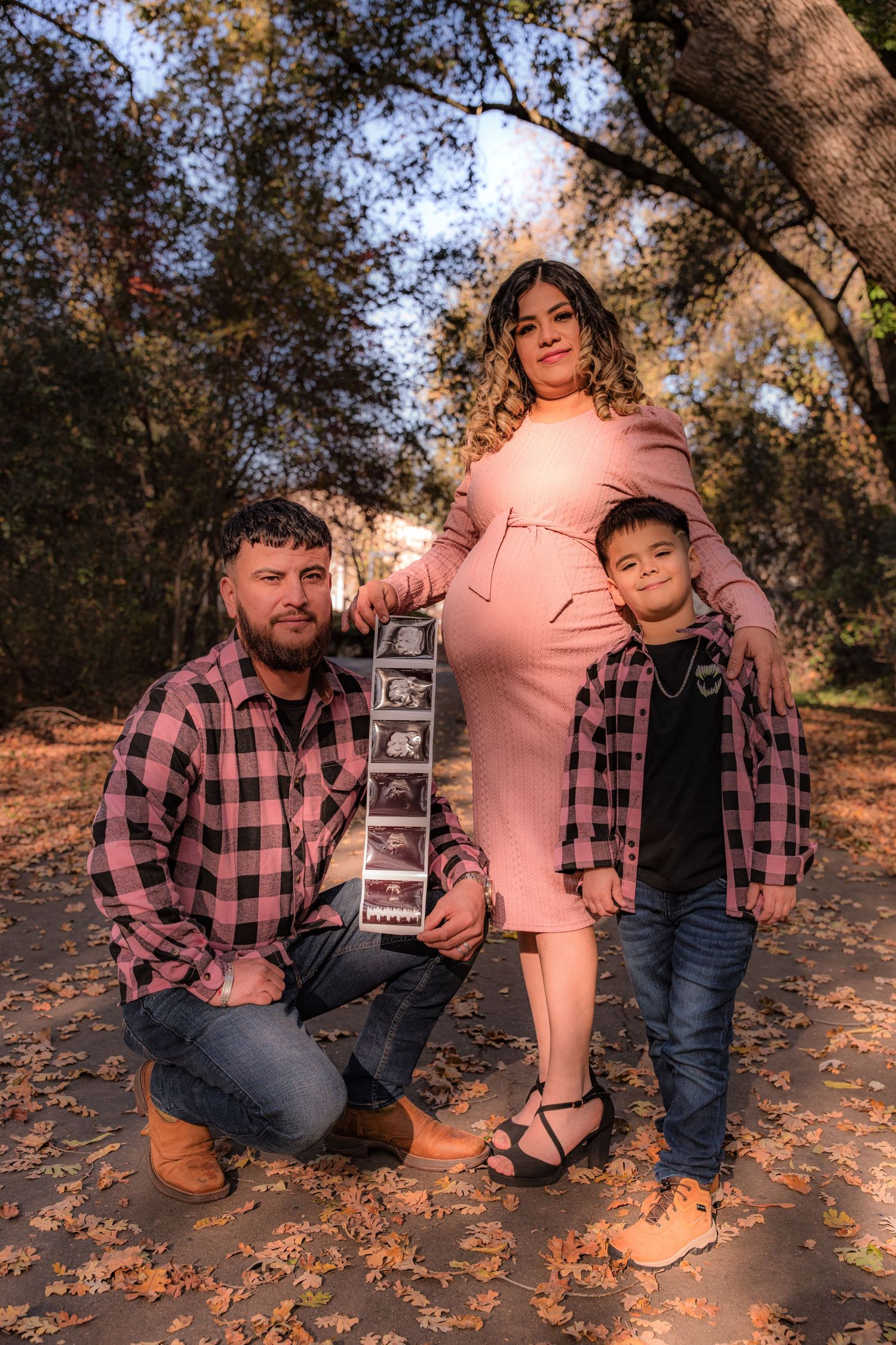 Family maternity photo session in autumn setting with ultrasound photos.
