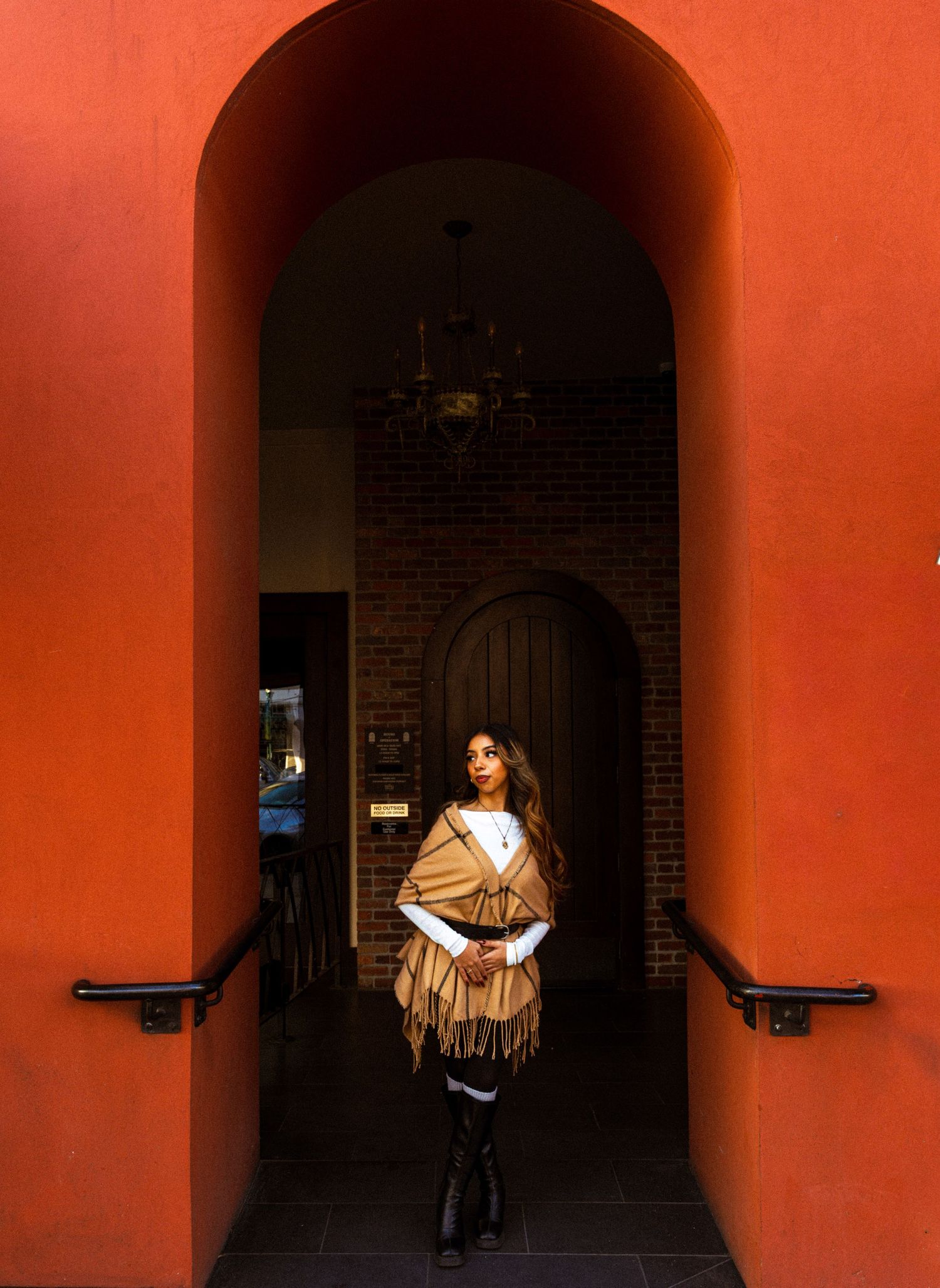 Dramatic fashion poses under red archways with dark shadows and architectural elements.