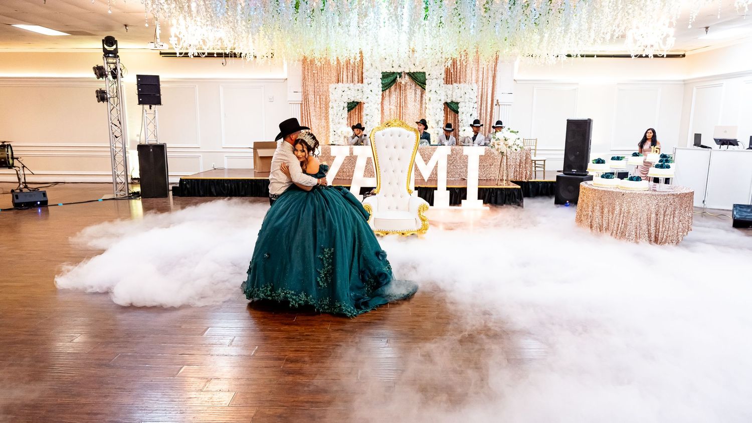 Wide view of an elegant ballroom with dancers and decorative lighting for a special celebration.