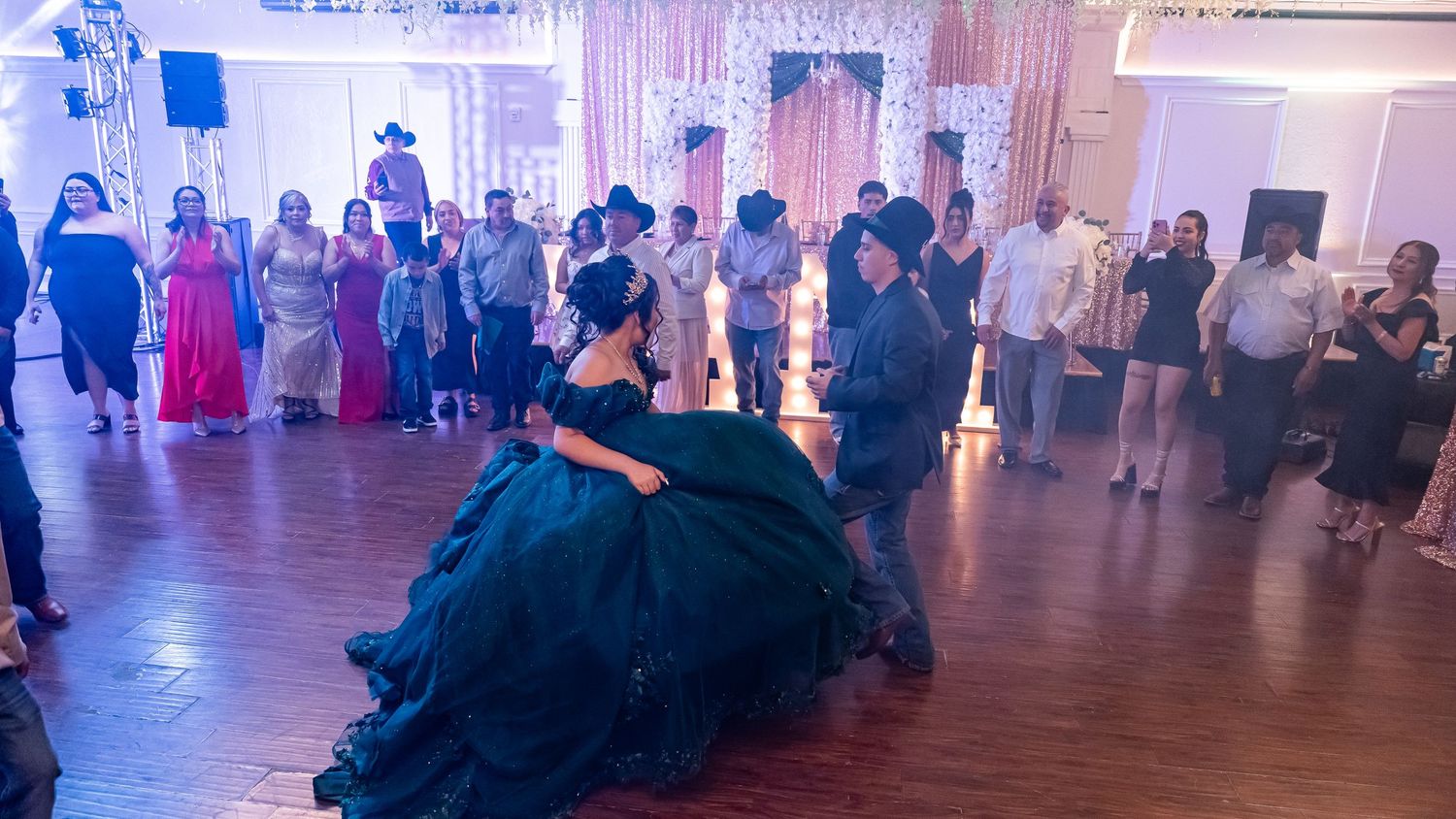 Panoramic shot of an elegant ballroom celebration with dramatic lighting and dancing guests.