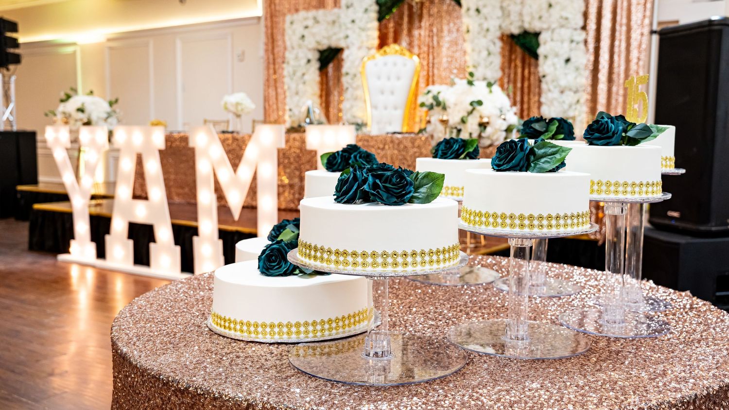 Elegant wedding reception setup with illuminated signs and sparkly tablecloths.