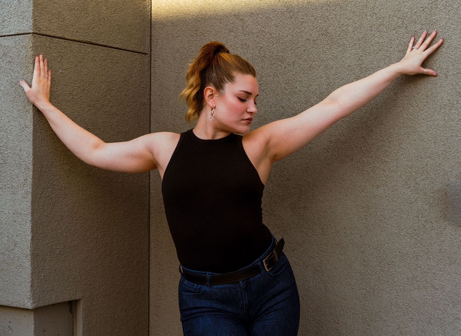Dance-inspired poses captured against a minimalist concrete wall background.
