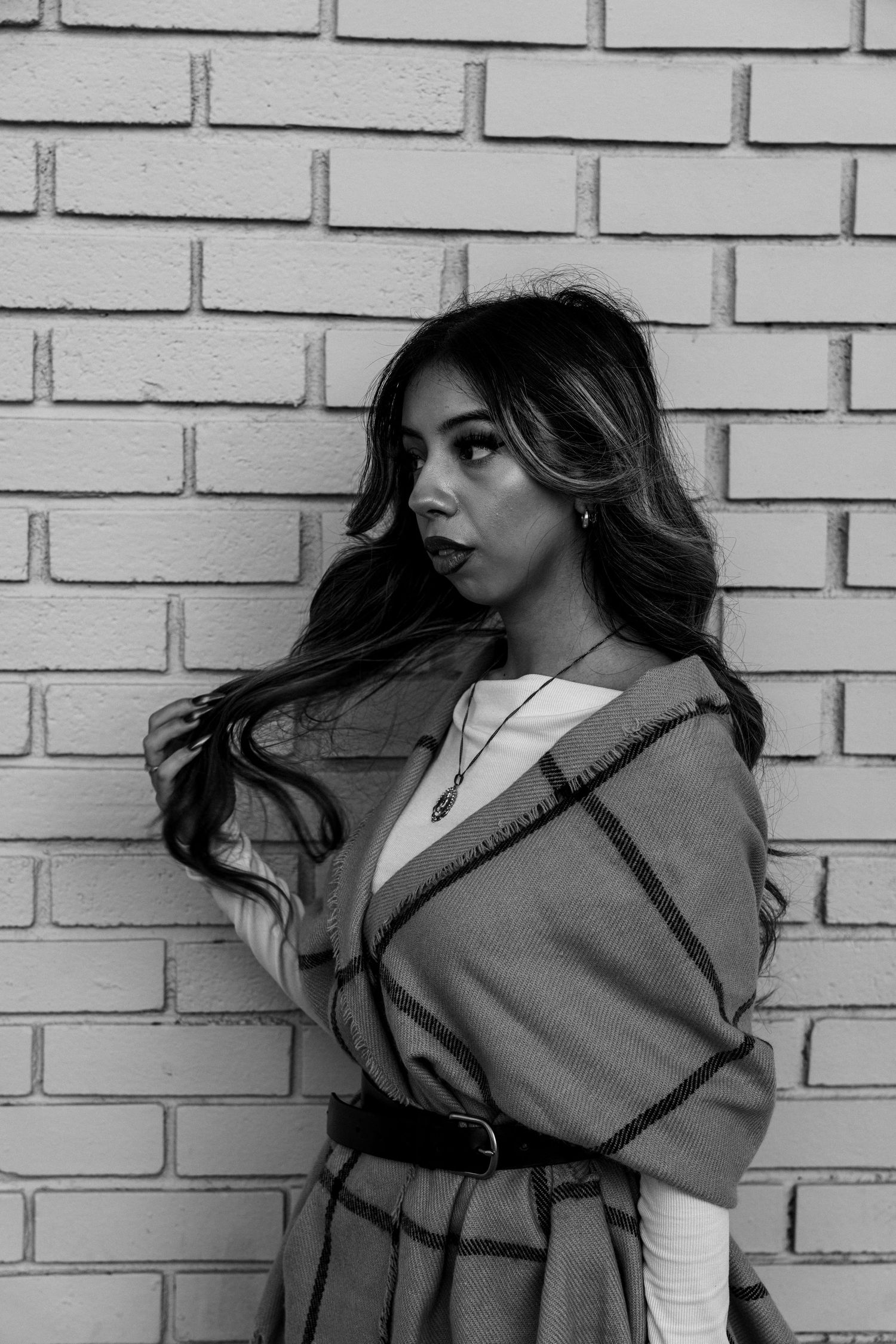A black and white portrait series showing dynamic movement against a brick wall background.