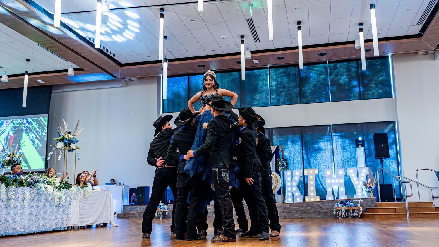 A panoramic shot of an elegant reception venue with modern lighting and wooden floors.