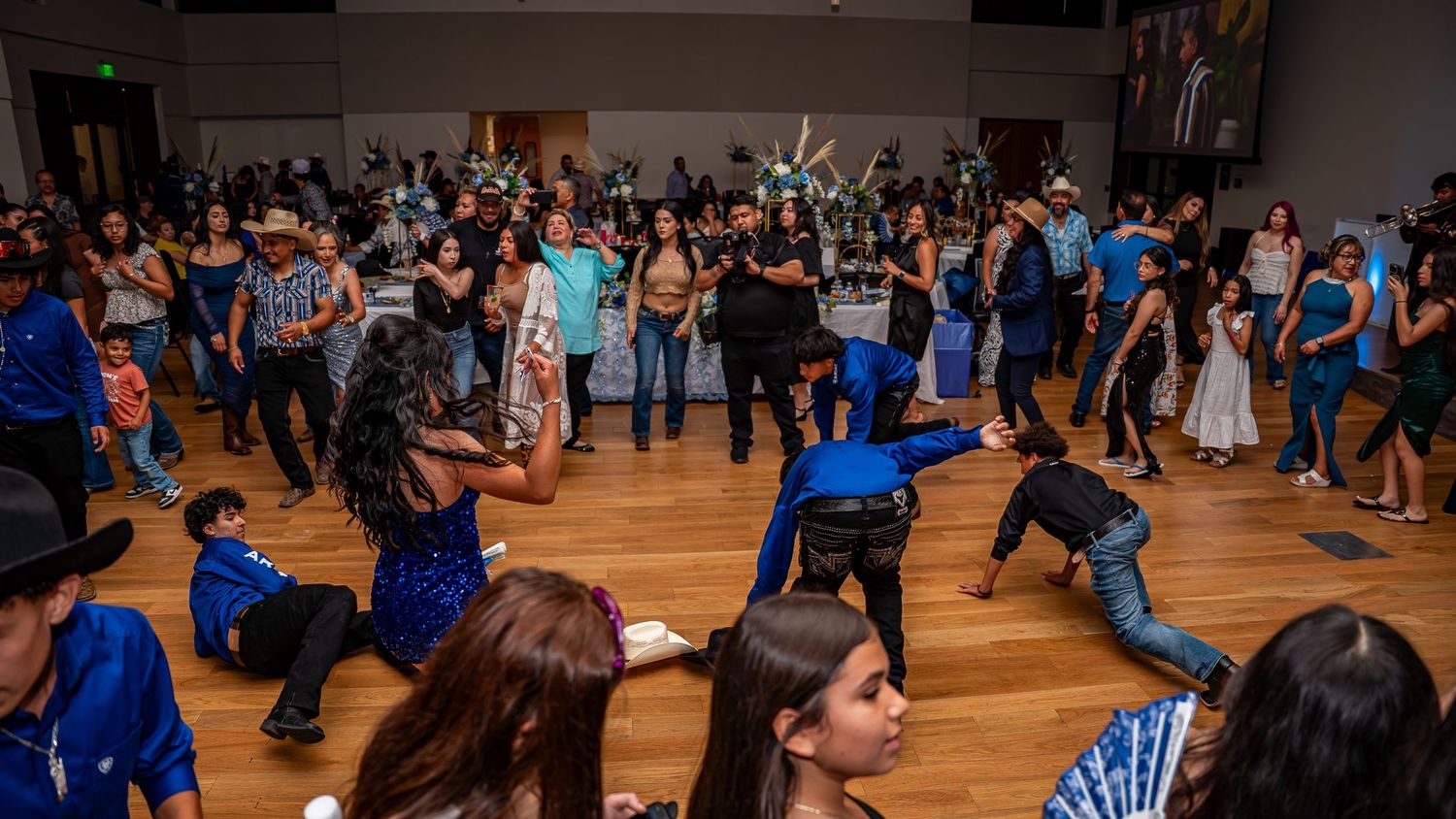 Dark panoramic shot of a crowded dance floor during an evening event.