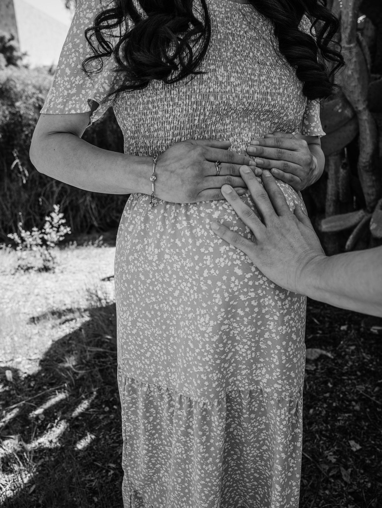 Black and white photo series showing close-up details of a polka dot dress in an outdoor garden setting.