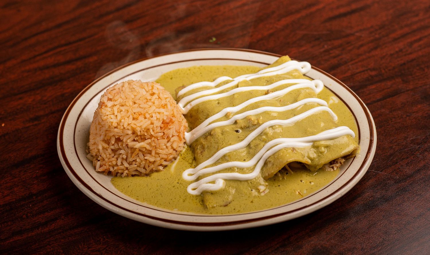 Mexican dishes with white sauce drizzle served on brown plates.