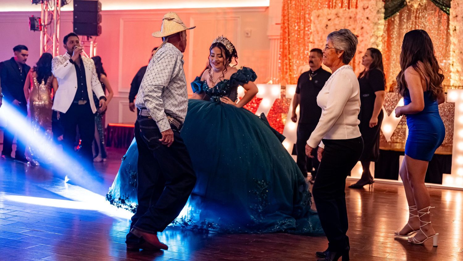 Wide angle view of a formal dance celebration with colorful lighting effects.