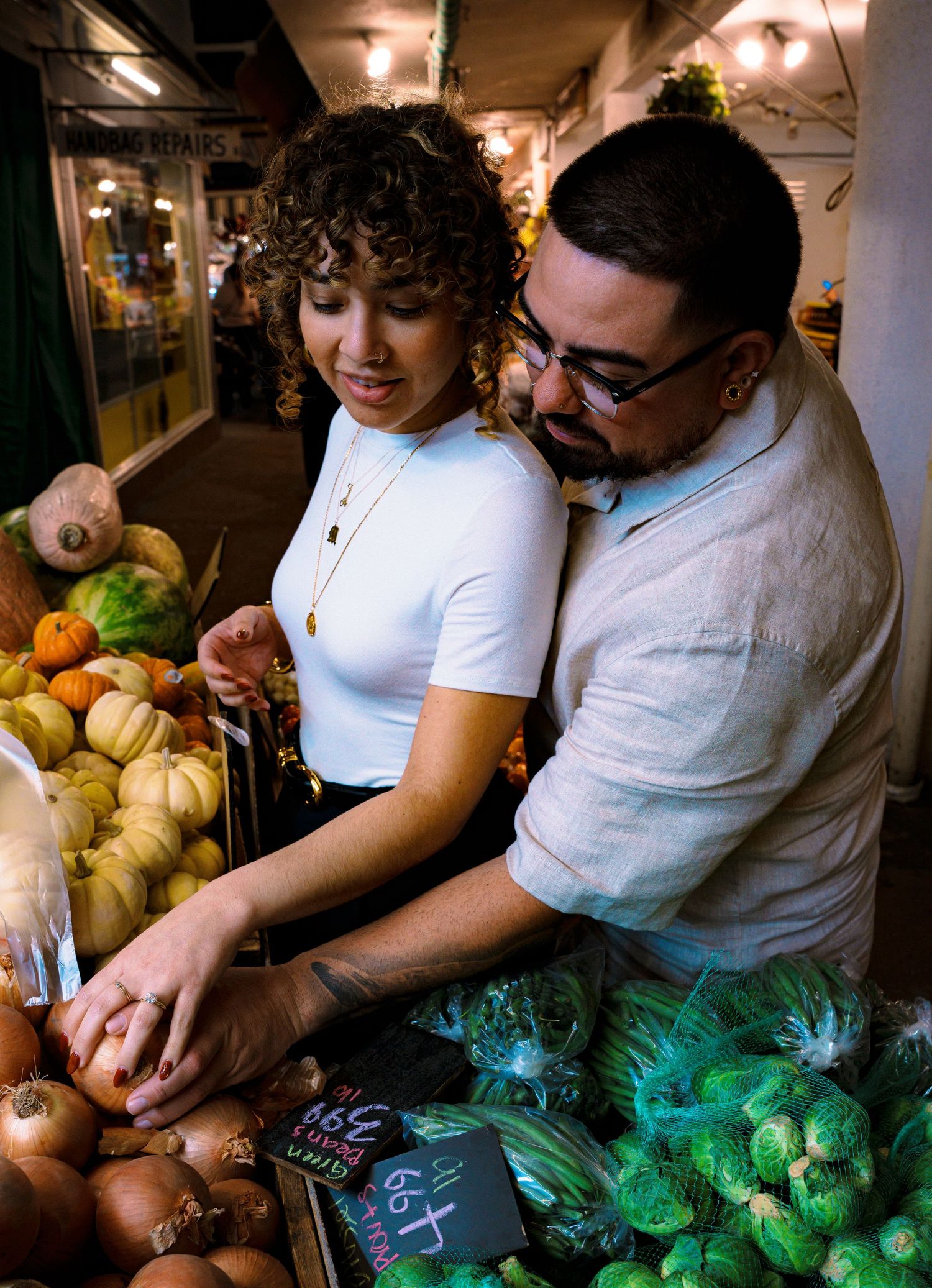 Two people selecting fresh produce together at a market stall.