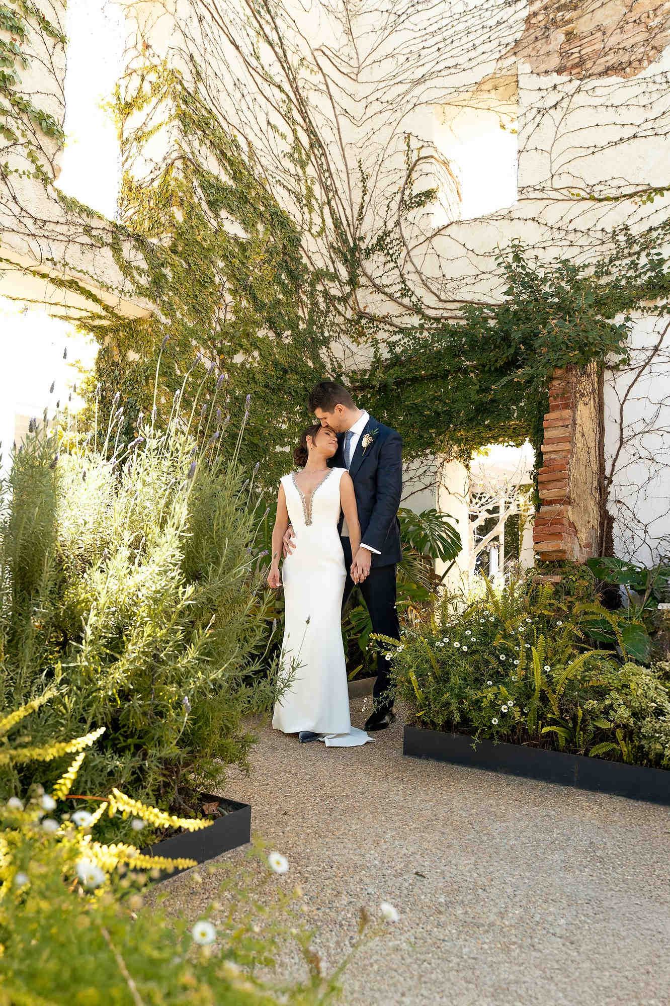 A sophisticated wedding couple posing in the historic inner courtyard of the El Telar de Miguel Martí venue