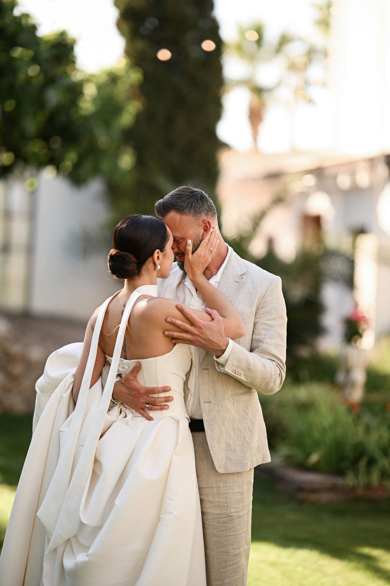 Back view of the first dance at Villa Paula as the bride holds her dress train, highlighting her beautiful updo hairstyle.
