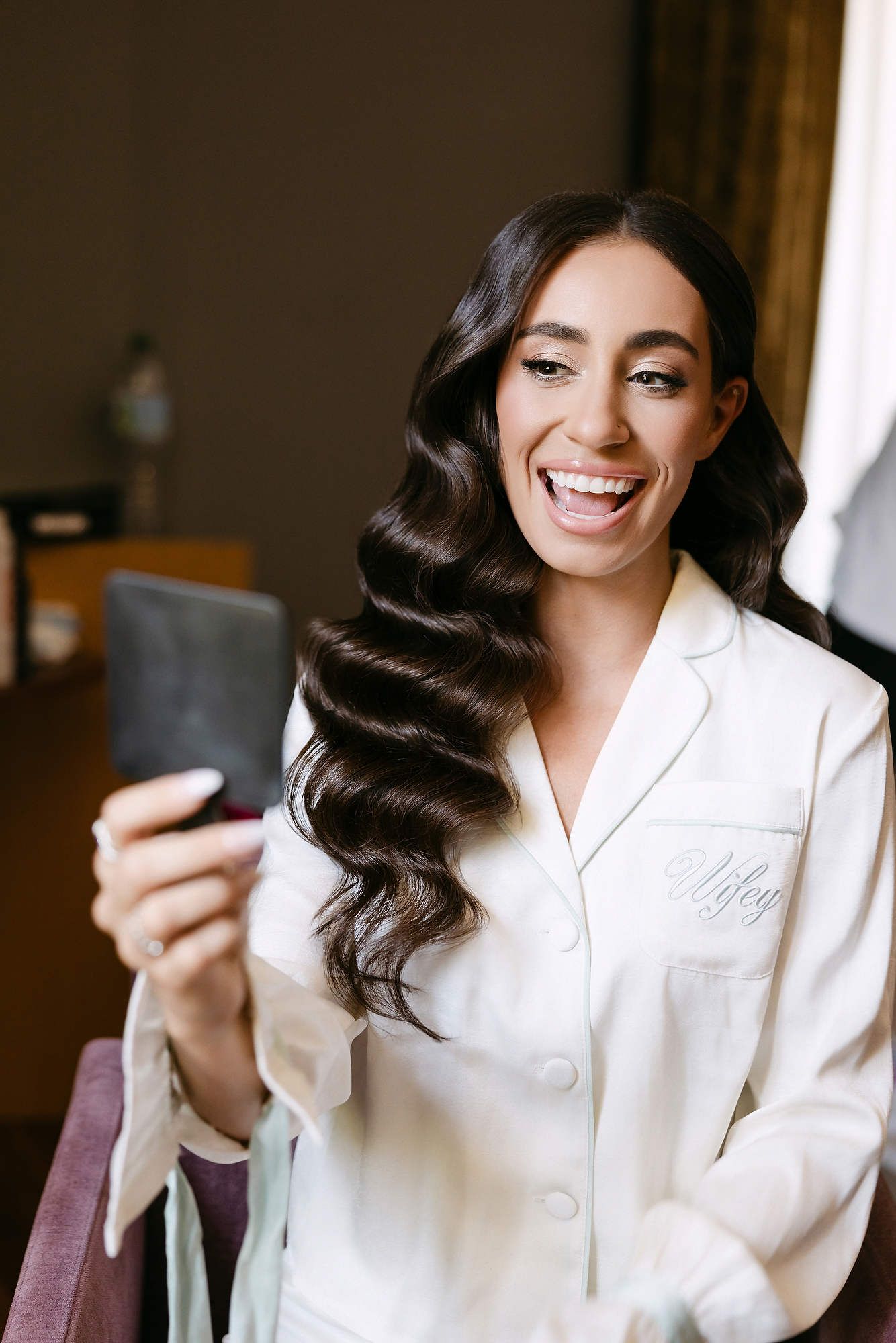 Bride admiring her professional makeup and hair styling in Barcelona. Perfect editorial bridal beauty for a luxury wedding in Spain