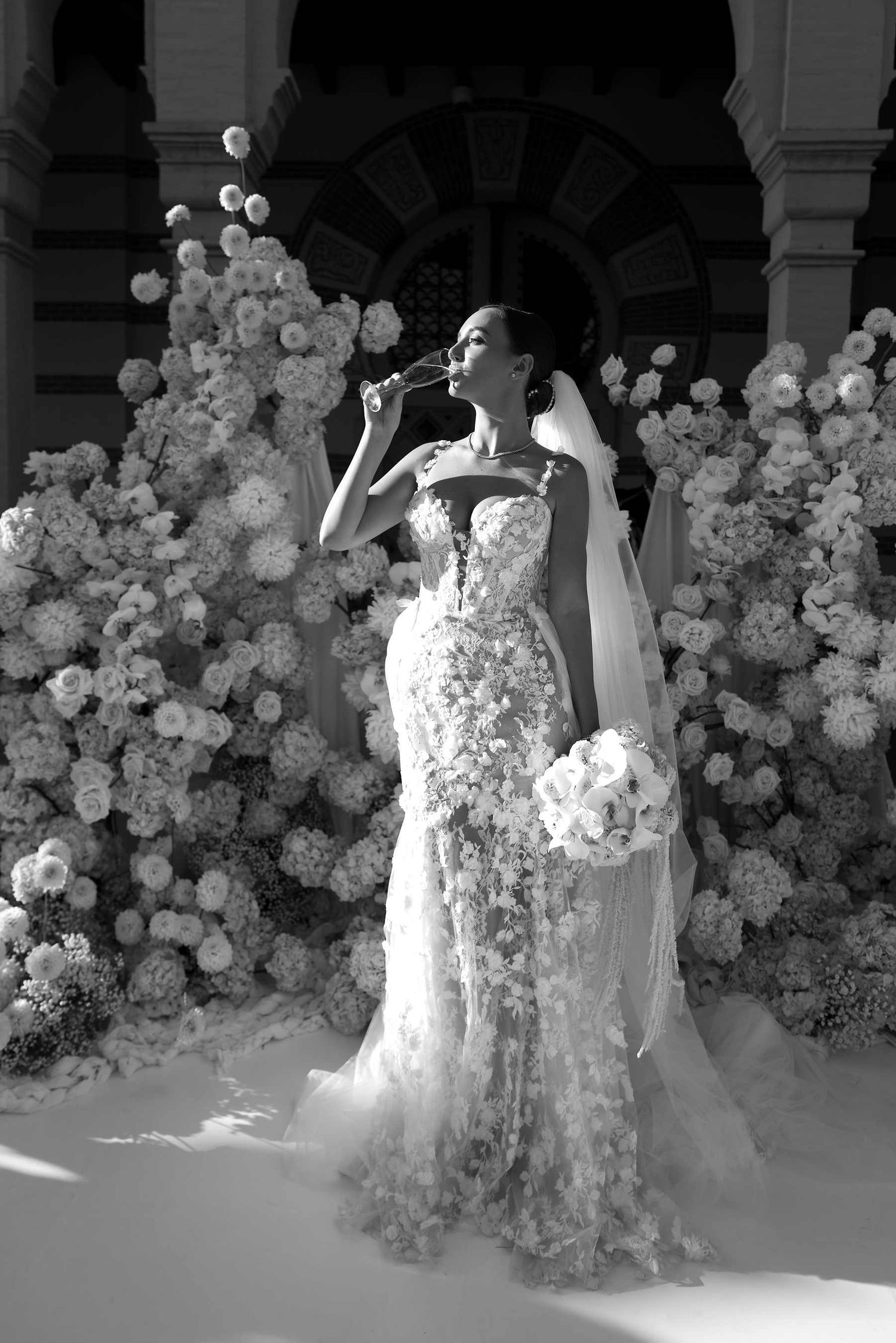 The bride enjoying champagne at the ceremony spot after the signing, featuring a long-lasting and radiant wedding makeup look