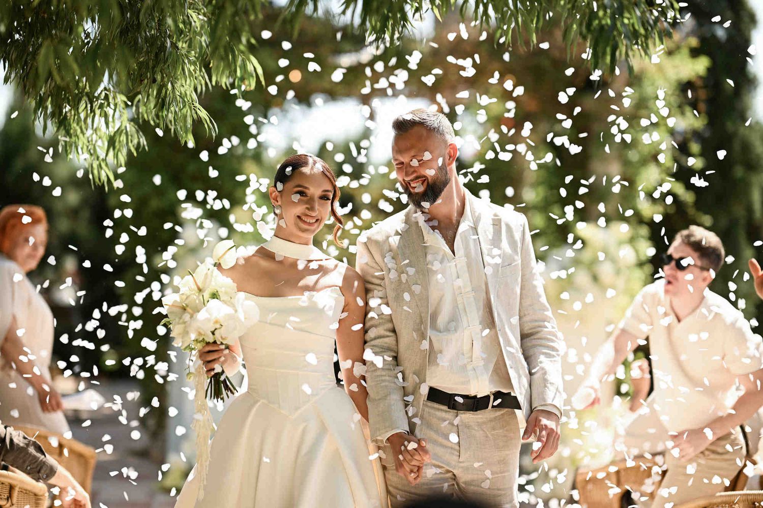 Newlyweds walking down the aisle as guests throw heart-shaped confetti during their wedding ceremony exit at Villa Paula Spain.