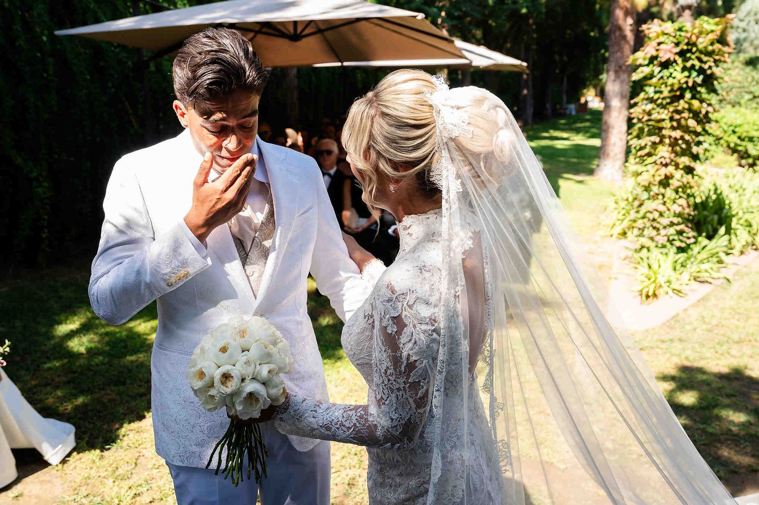 A powerful close-up of the groom's emotional reaction and tears upon seeing the bride for the first time during the ceremony.
