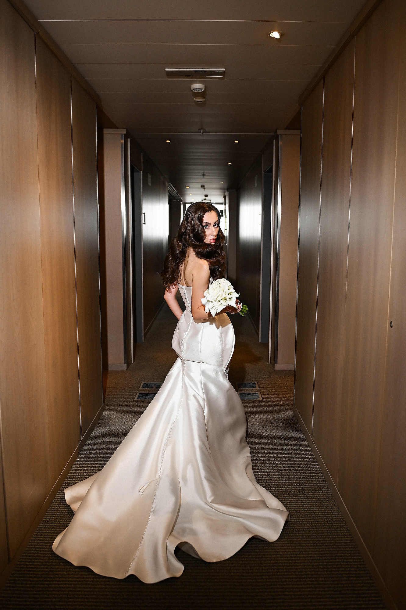 Fashion-style bride with elegant waves running through a hotel corridor. Editorial bridal hair and makeup for a high-end Spanish wedding.