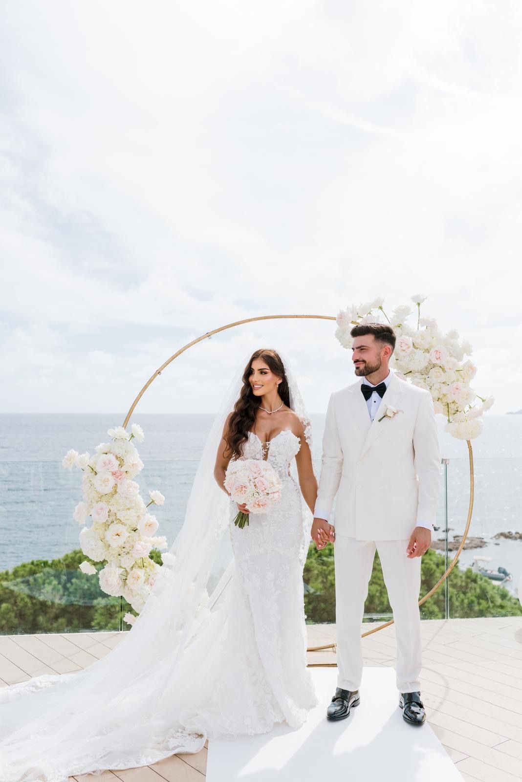 Newlyweds at a sea-view ceremony on Ibiza. Professional bridal makeup and long-lasting hair styling for a luxury Balearic Islands wedding.