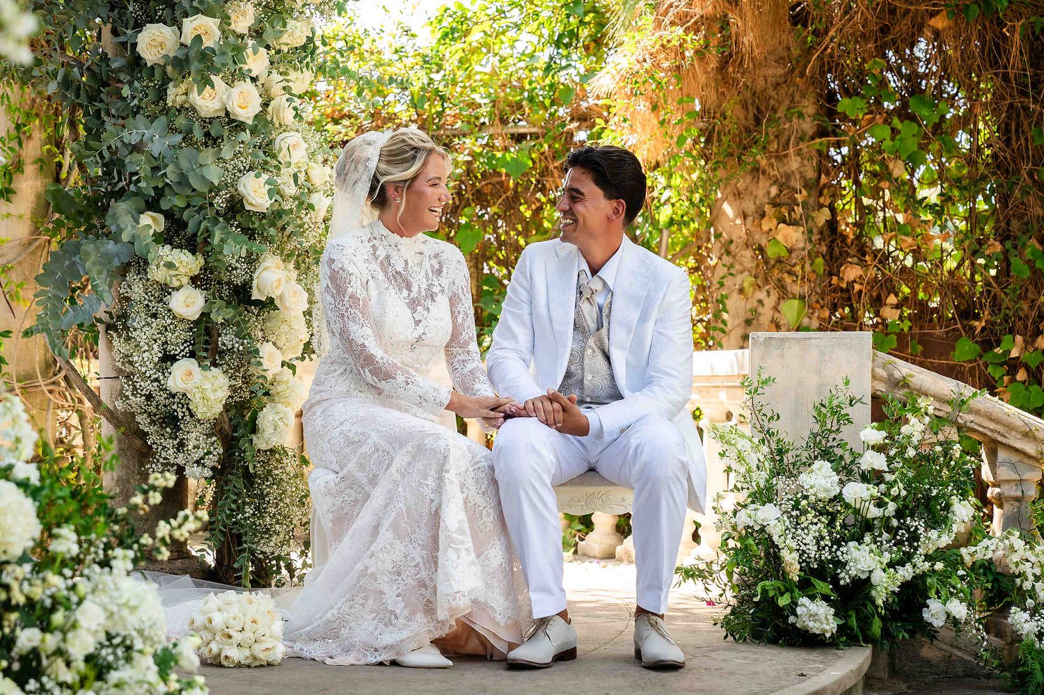The couple seated during their elegant wedding ceremony, highlighting the sophisticated and romantic atmosphere of the venue.