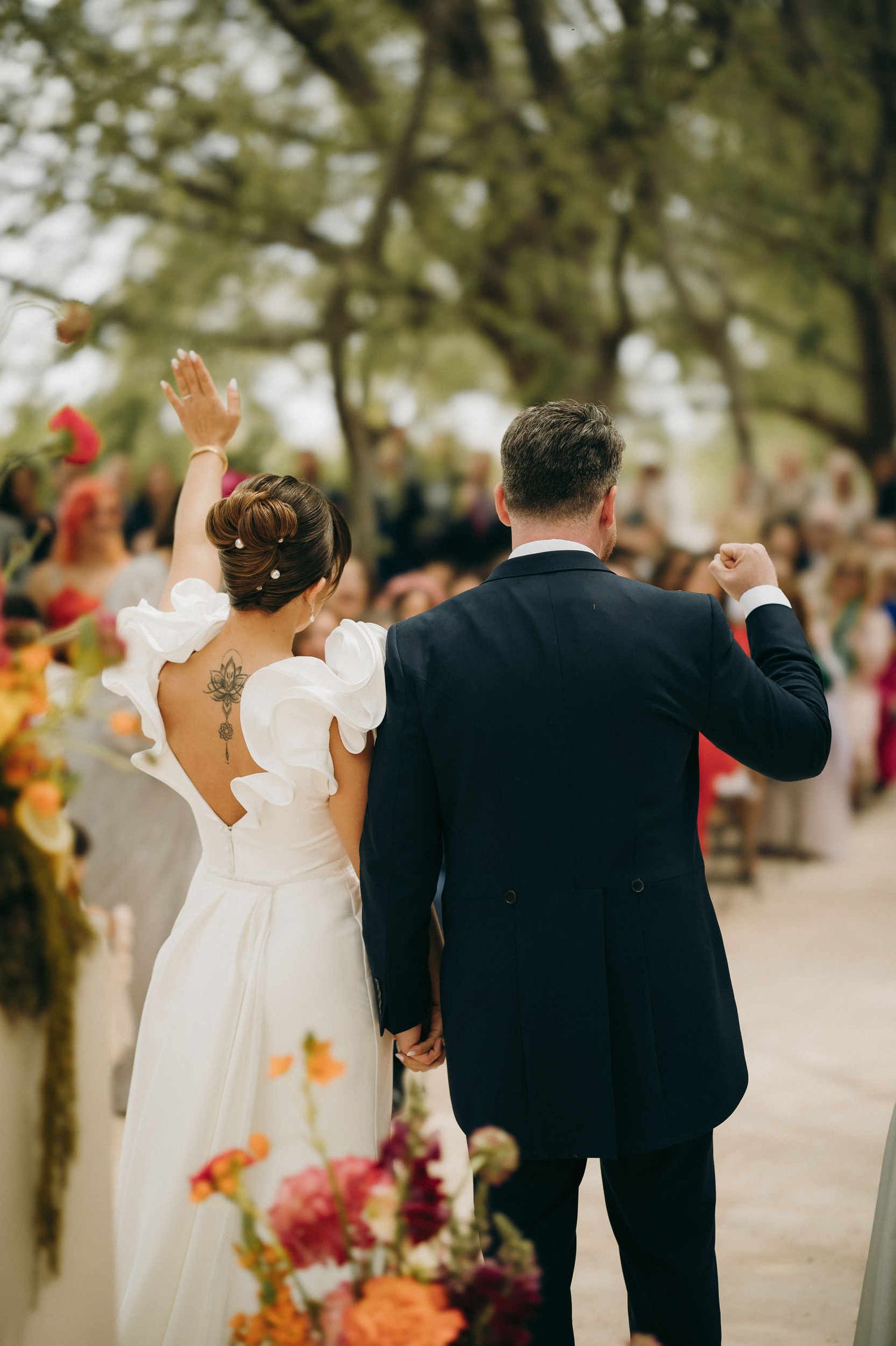 Bride and groom at the ceremony in Spain, back view showing a professional wedding hairstyle. Elegant bridal hair design for destination