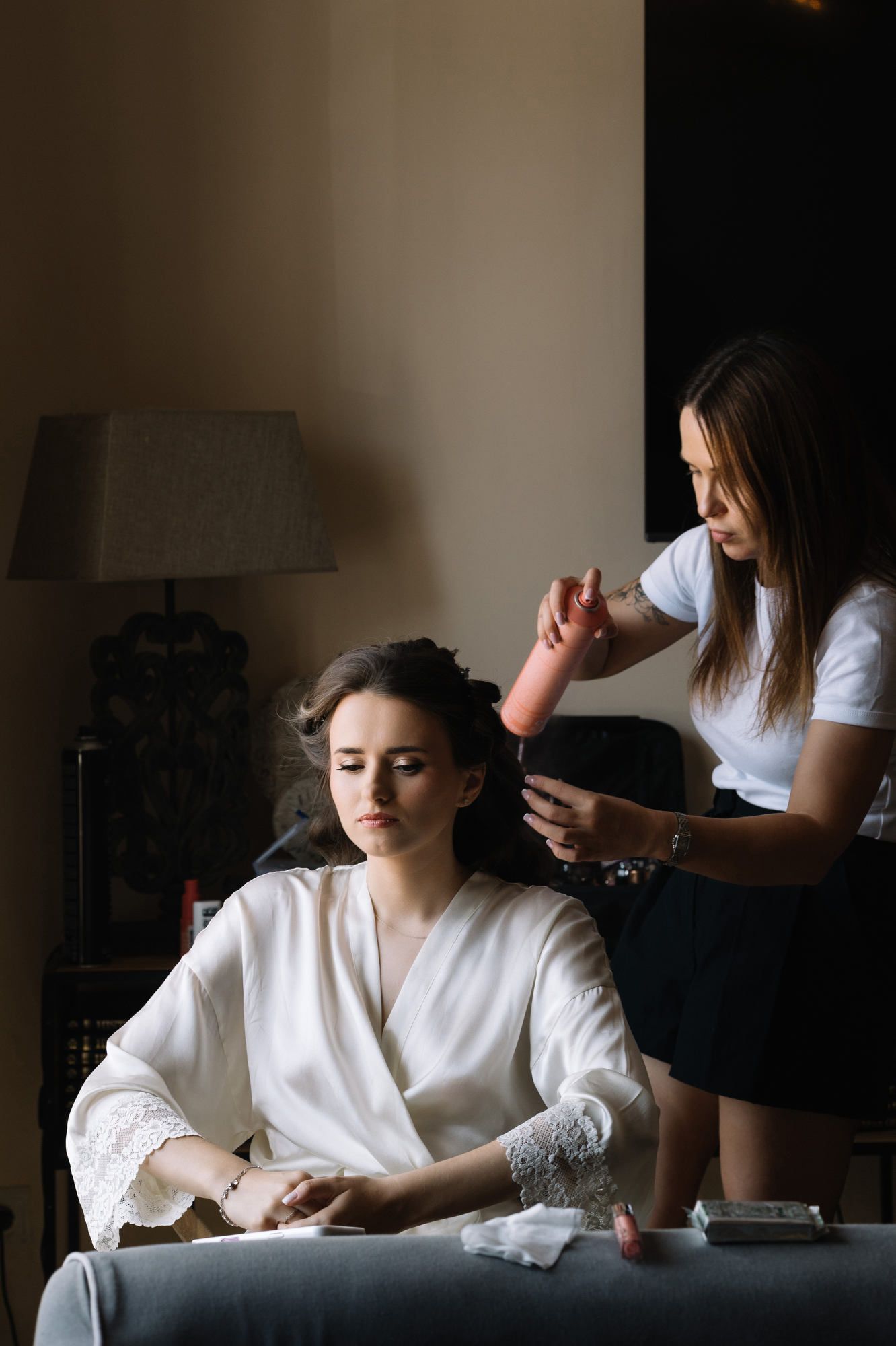 Professional makeup artist Anastasia Larionova using hairspray to finish the bride's hairstyle at the Alqueria del Xúquer venue in Valencia.