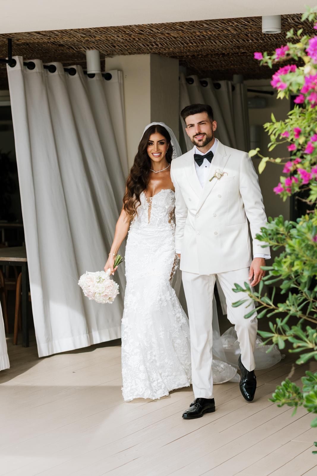 The bride and groom making their grand entrance at the wedding ceremony in ME Ibiza, showcasing a flawless and elegant bridal look.
