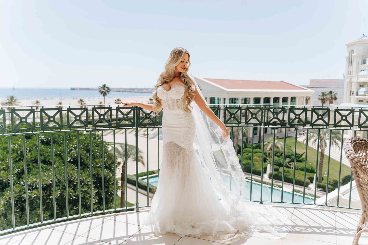 A  bride with a polished waves wedding hairstyle on the terrace of Las Arenas resort overlooking the Malvarrosa beach at day