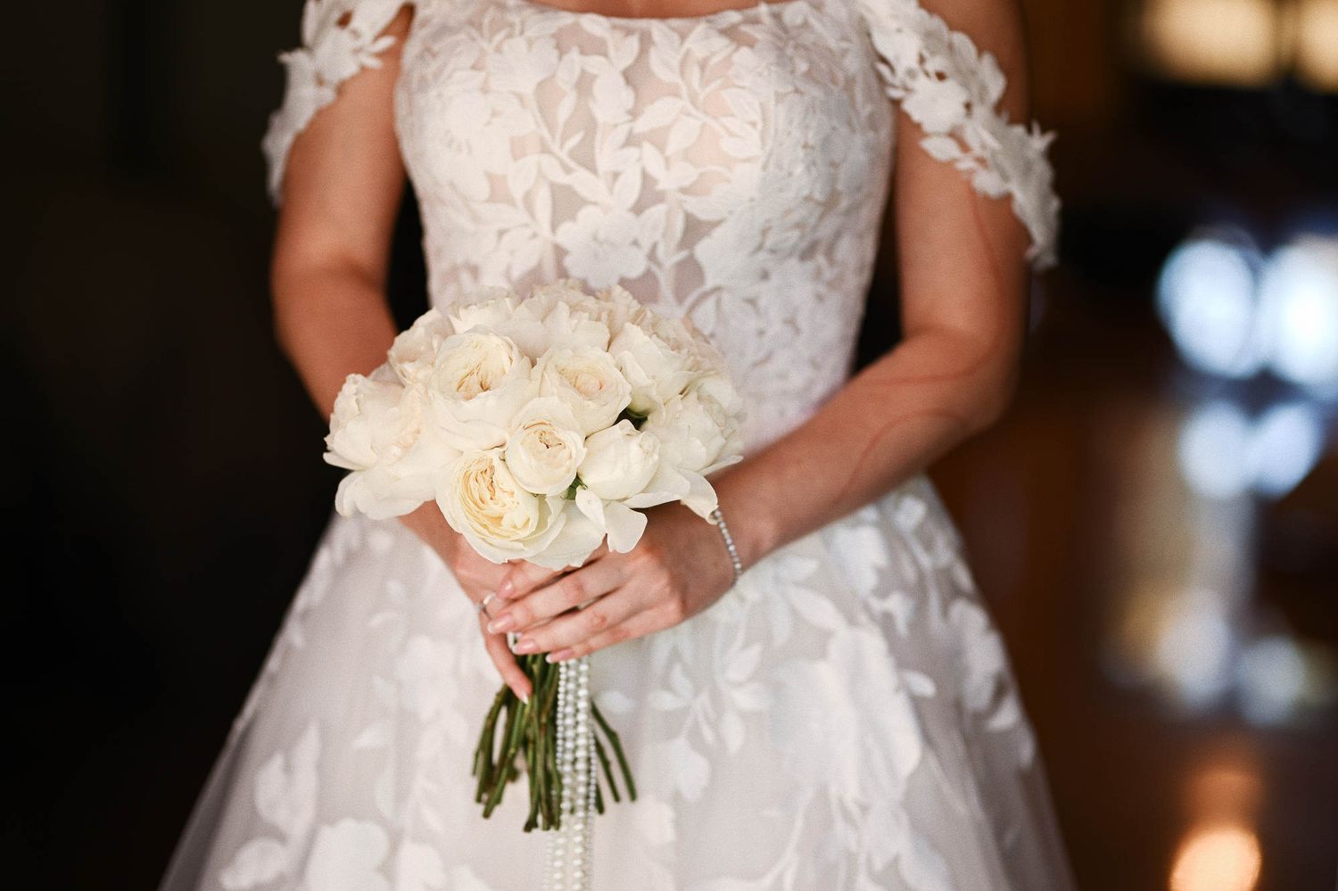 Close-up of the elegant bridal bouquet against the texture of her wedding dress at Finca El Senoret estate in Spain.