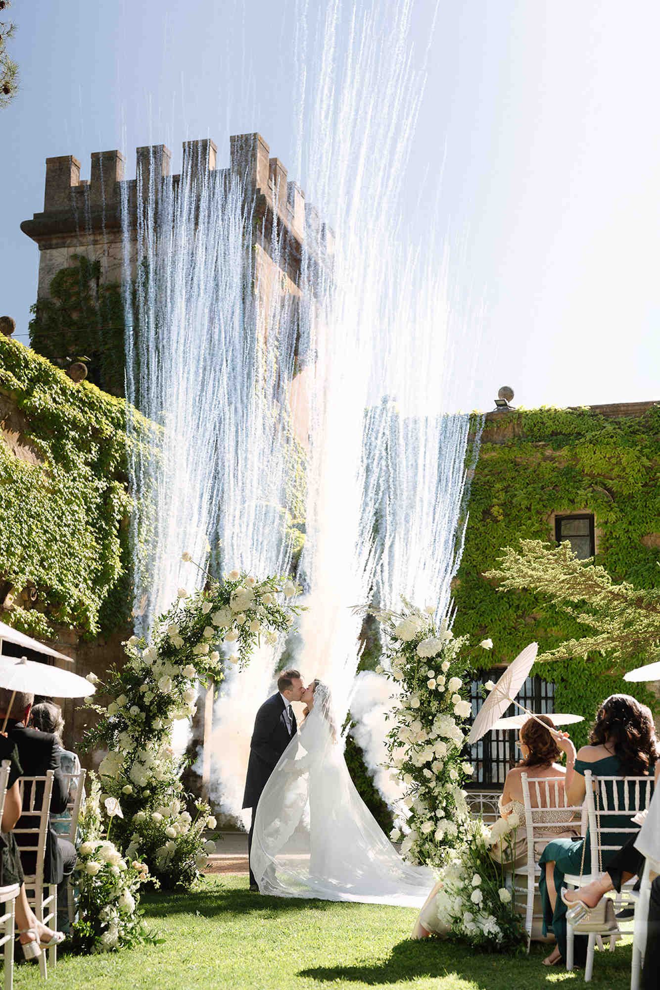 Bride and groom kissing with spectacular white fireworks during their wedding ceremony at the historic Finca Torrefiel estate.
