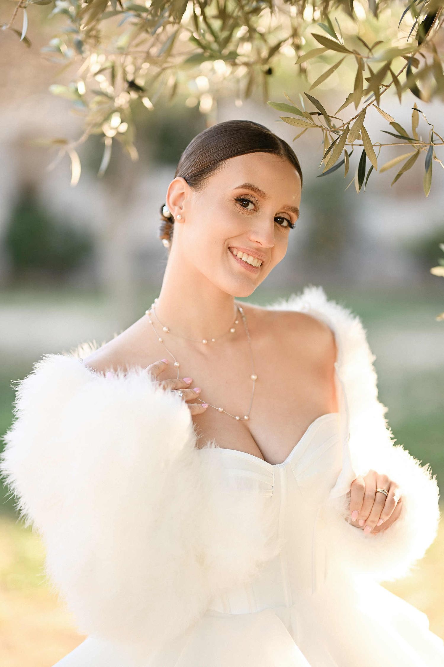 Elegant bridal low bun hairstyle for a winter wedding in Valencia, featuring a bride in a stylish fur coat and professional hair styling