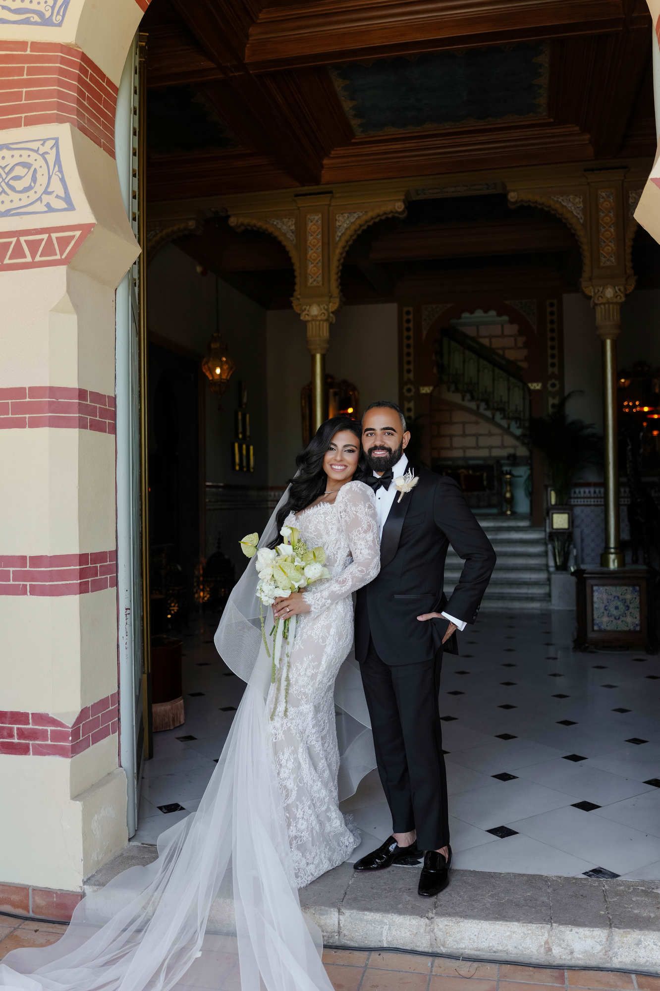 Newlyweds posing at the grand entrance of Gran Villa Rosa, showcasing luxury bridal styling and elegant interior design.