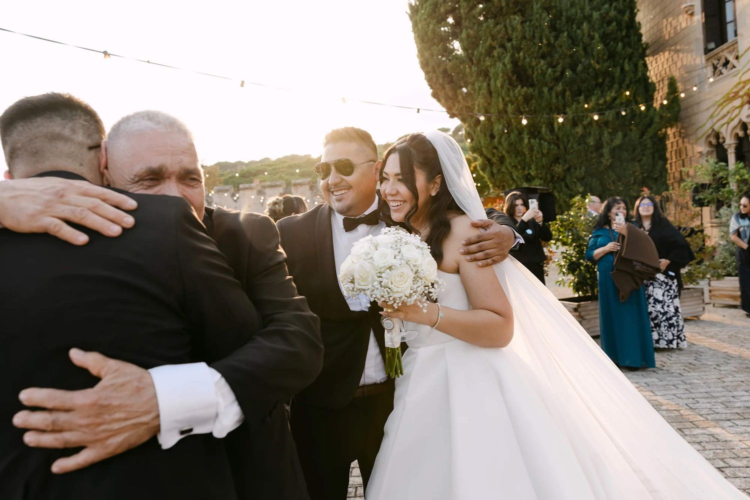 A joyful reportage shot of the bride hugging guests, demonstrating the long-lasting resilience of her professional bridal hair and makeup.
