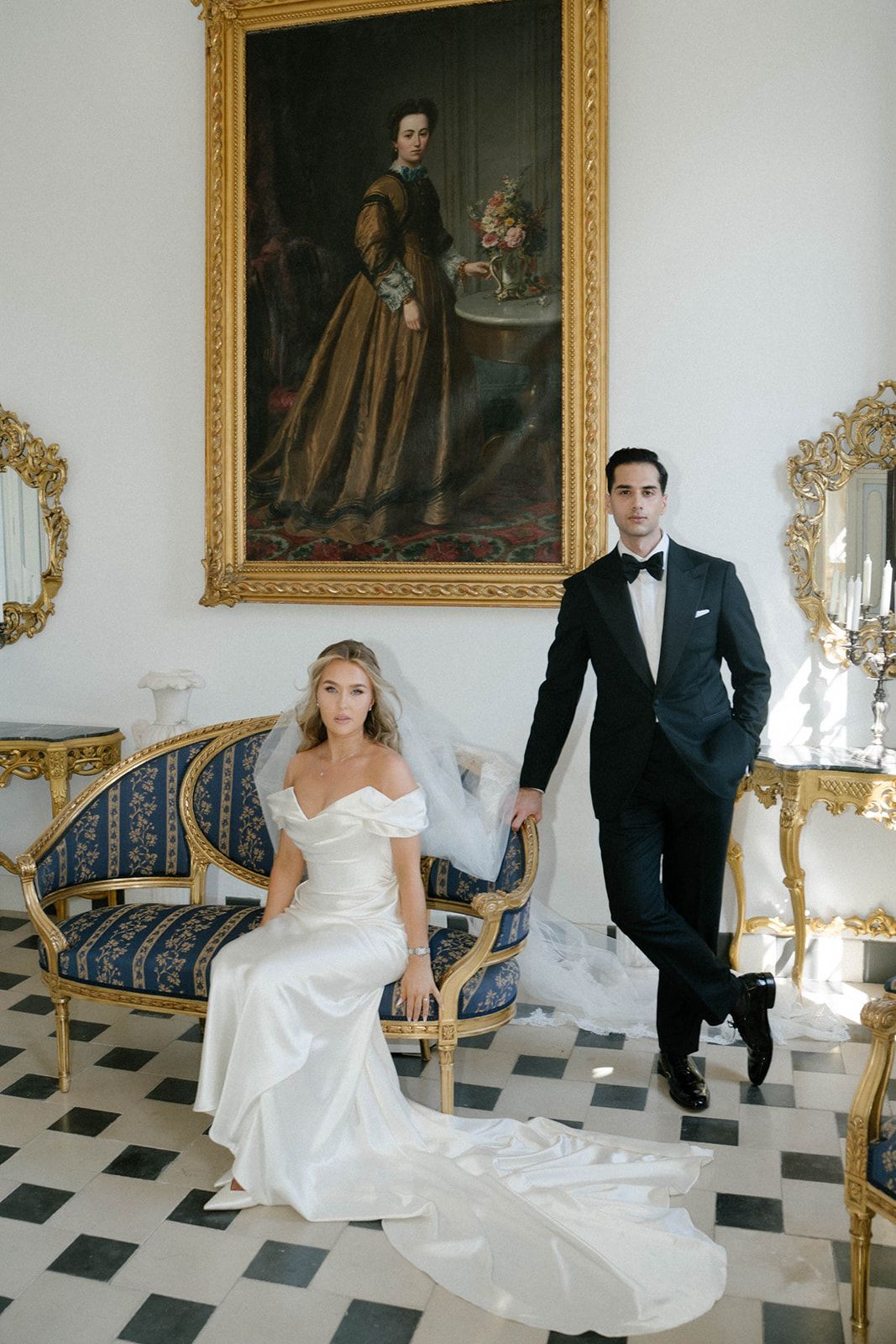 Full length wedding portrait of a bride and groom showing the long dress train in the luxury interior of Finca Marqués de Montemolar.