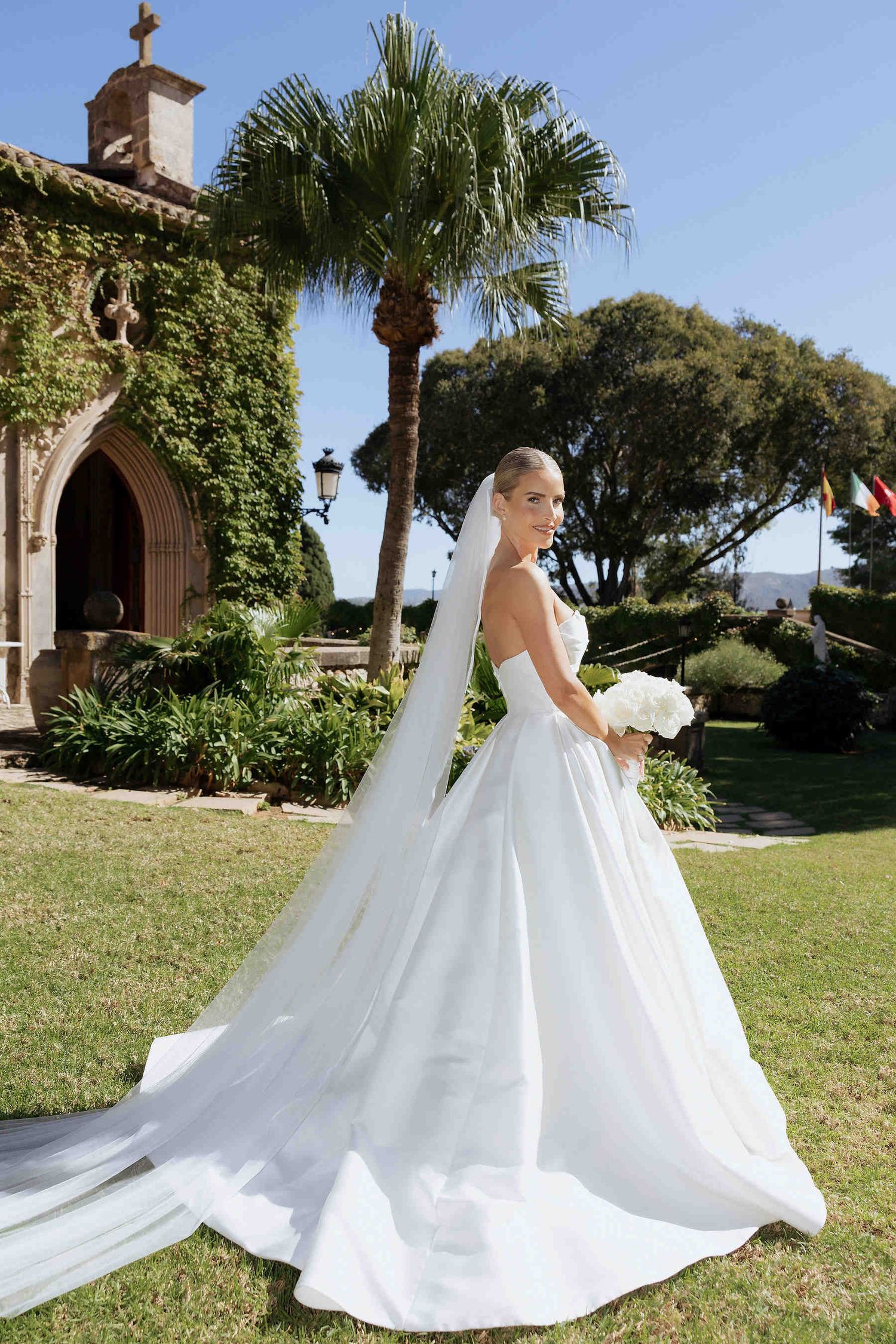 A romantic bride posing in the lush botanical gardens of Casa Santonja for a luxury destination wedding in Valencia.