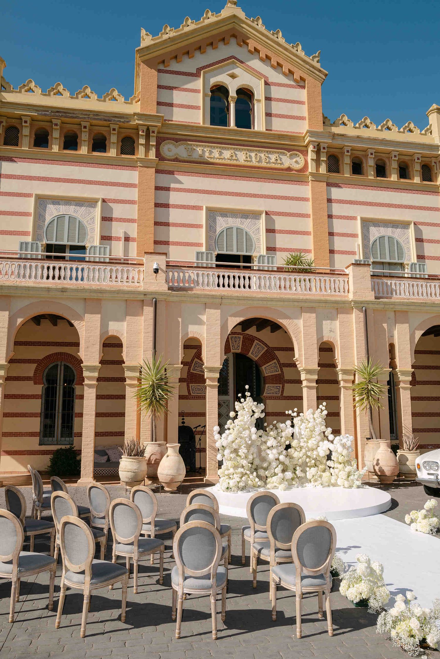 Luxury wedding ceremony setup at Gran Villa Rosa with elegant floral arch and chairs waiting for guests in the Mediterranean garden