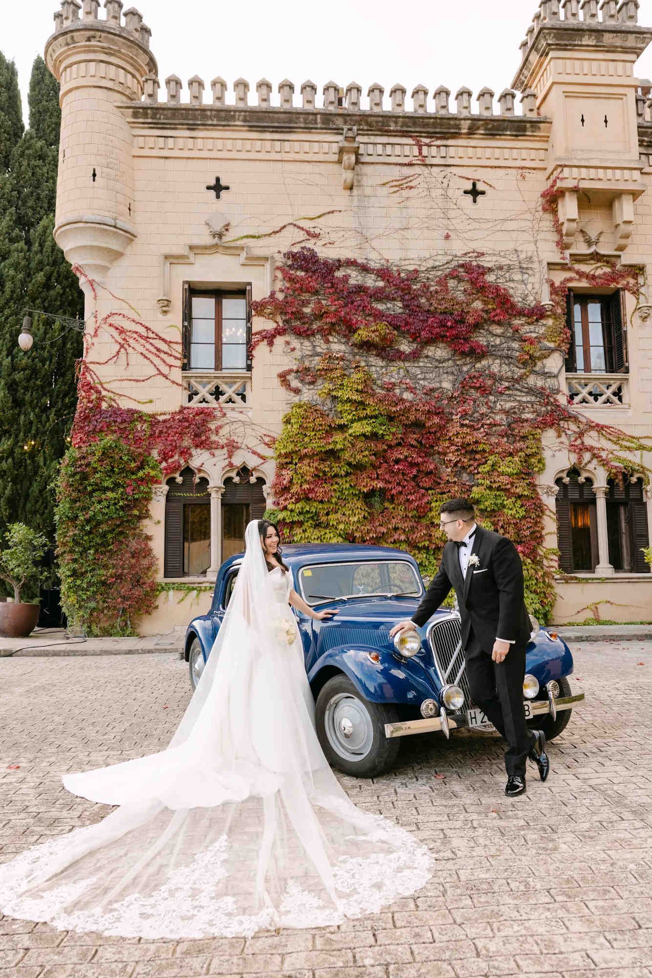 Bride and groom with a retro car at a Spanish castle. Professional bridal beauty and styling for a luxury destination wedding in Spain.