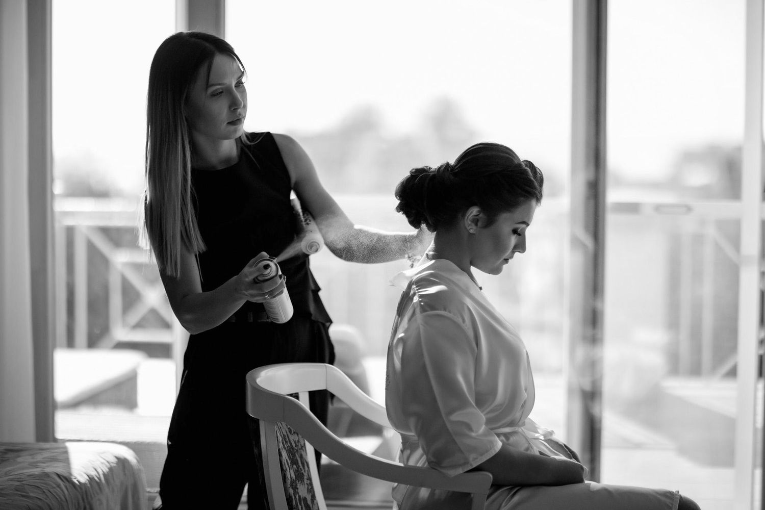 Professional makeup artist and hair stylist preparing a bride in a Spanish hotel. High-end bridal beauty for luxury destination weddings.